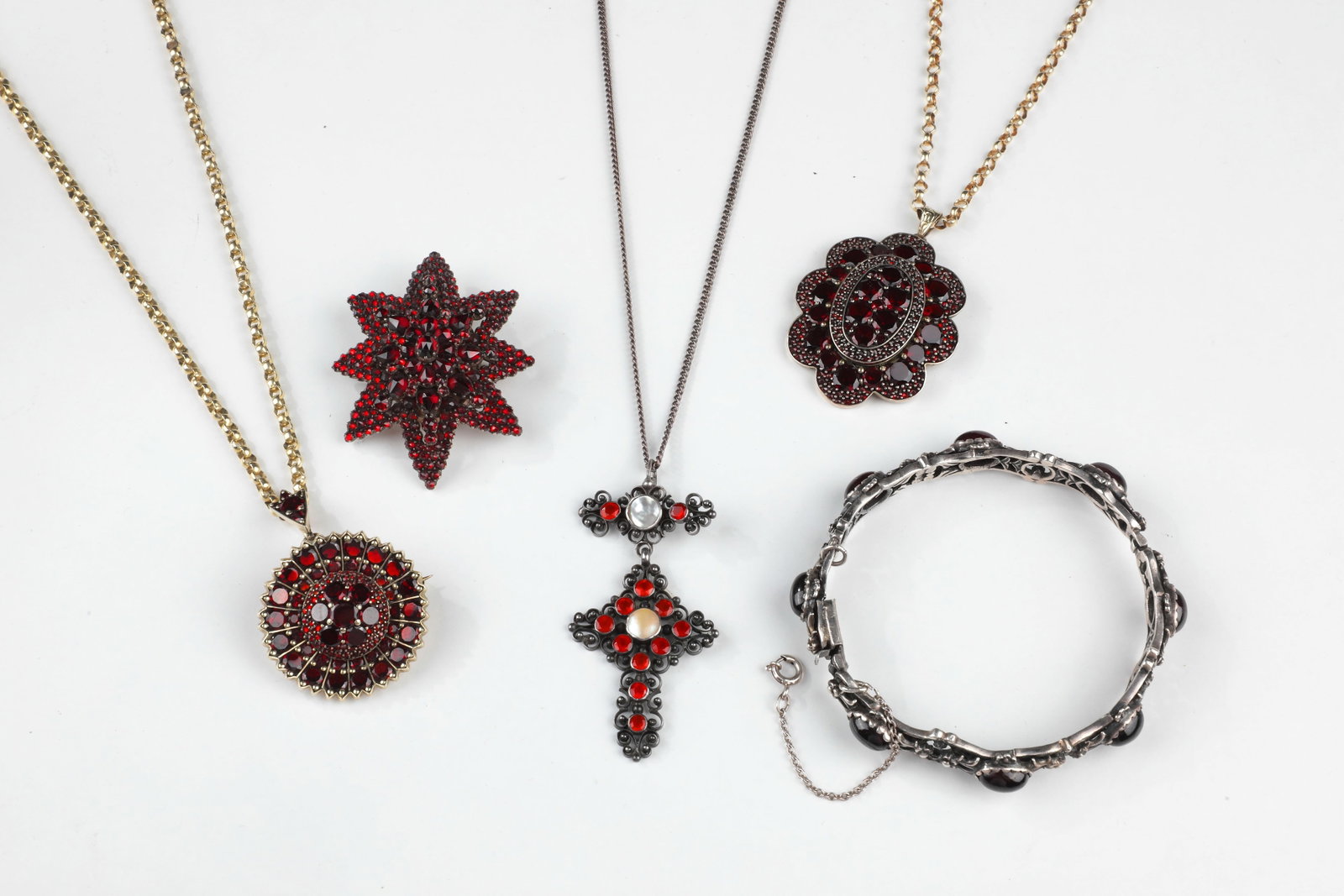 Mixed Lot Garnet Jewellery, Five-Piece: Mixed lot of garnet jewelry, five-piece Consisting of a bracelet with garnet cabochons, box clasp and safety chain; a brooch with a photo compartment on the back and pin; as well as three necklaces