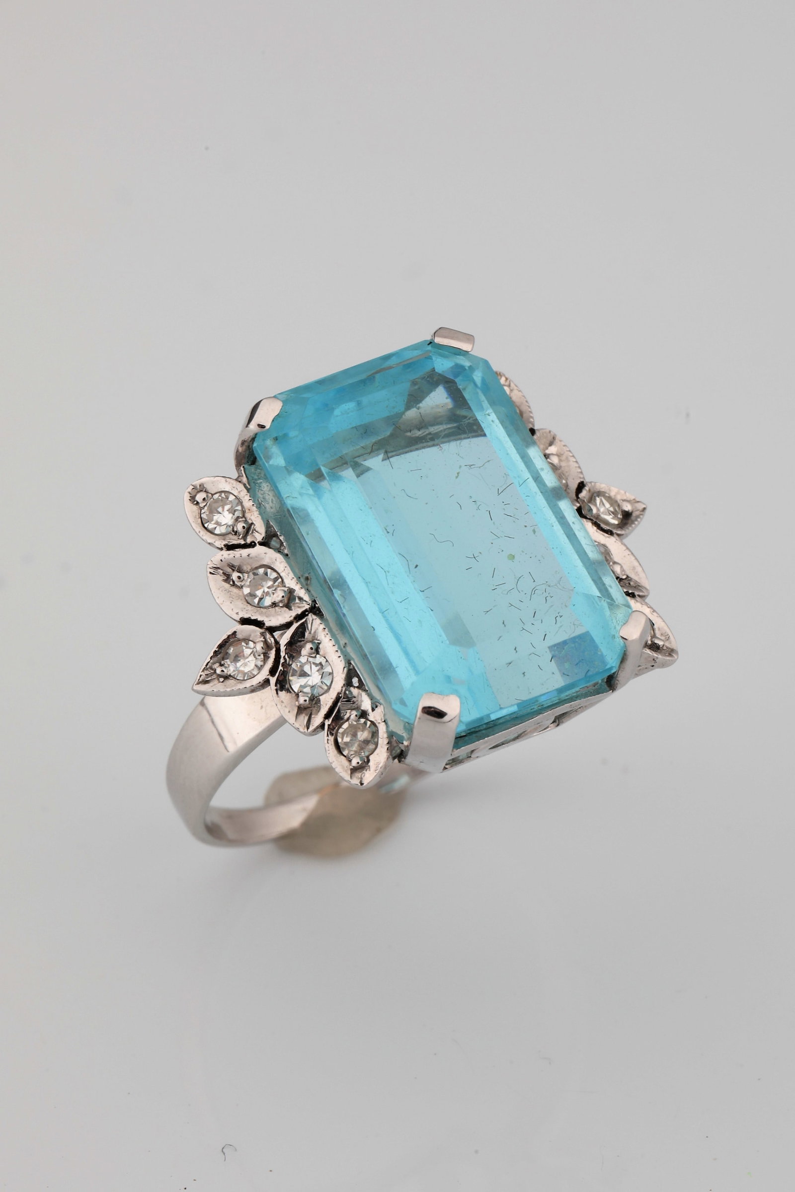 Cocktail ring: Cocktail ring ring made of at least 21.6 kt/ 900 WG (acid tested), in the style of the so-called fashionable mid-century of the 1950s. Ring head with large, transparent, ocean-blue coloured stone in
