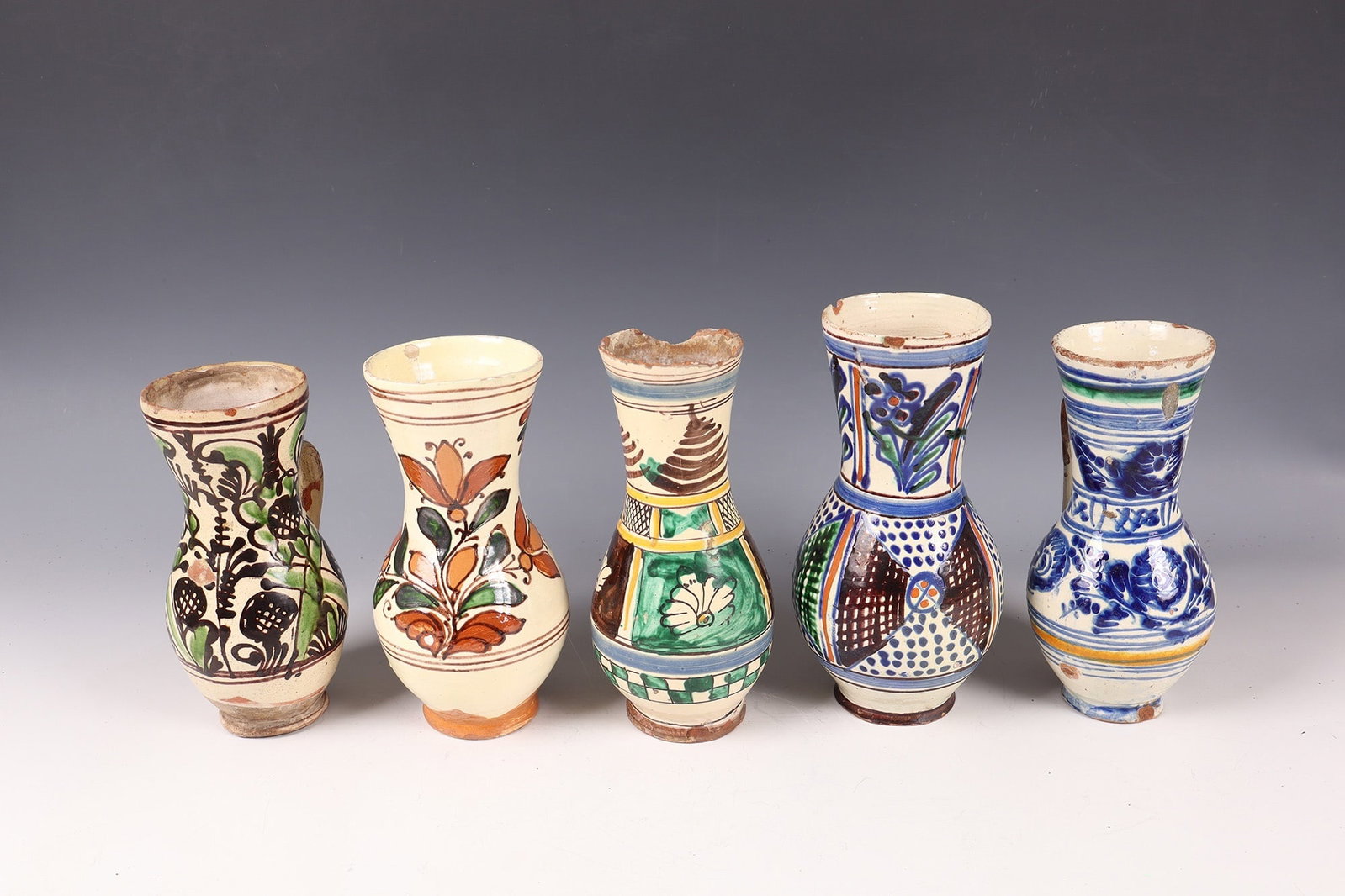Mixed Lot of 5 Pear Jugs: Mixed lot of five birch jugs Transylvania, various. Manufactories, 19th and 20th centuries Polychrome, geometric and floral ornaments on an ivory background. Some with signs of use. H. 20 - 23 cm