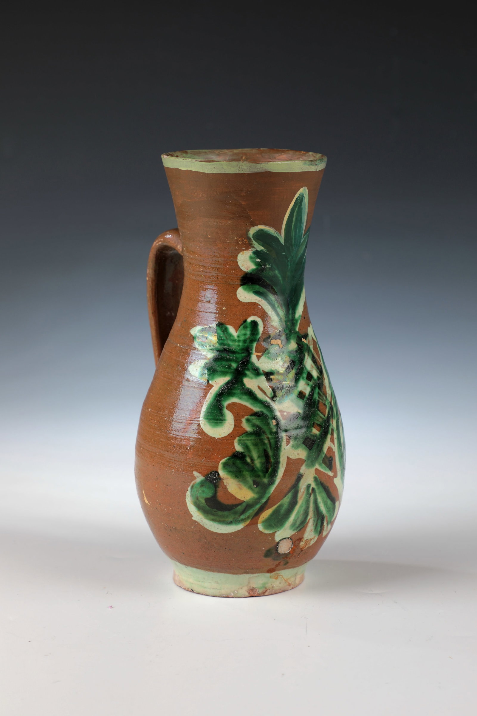 Birnkrug: Pear jug Transylvania Niemesch, 18th century Stylized floral decoration in white and green. Muzzle rim restored. H. 21.5 cm Cf. lit.: Istvan Csupor, Volkstümliche Töpferkunst in