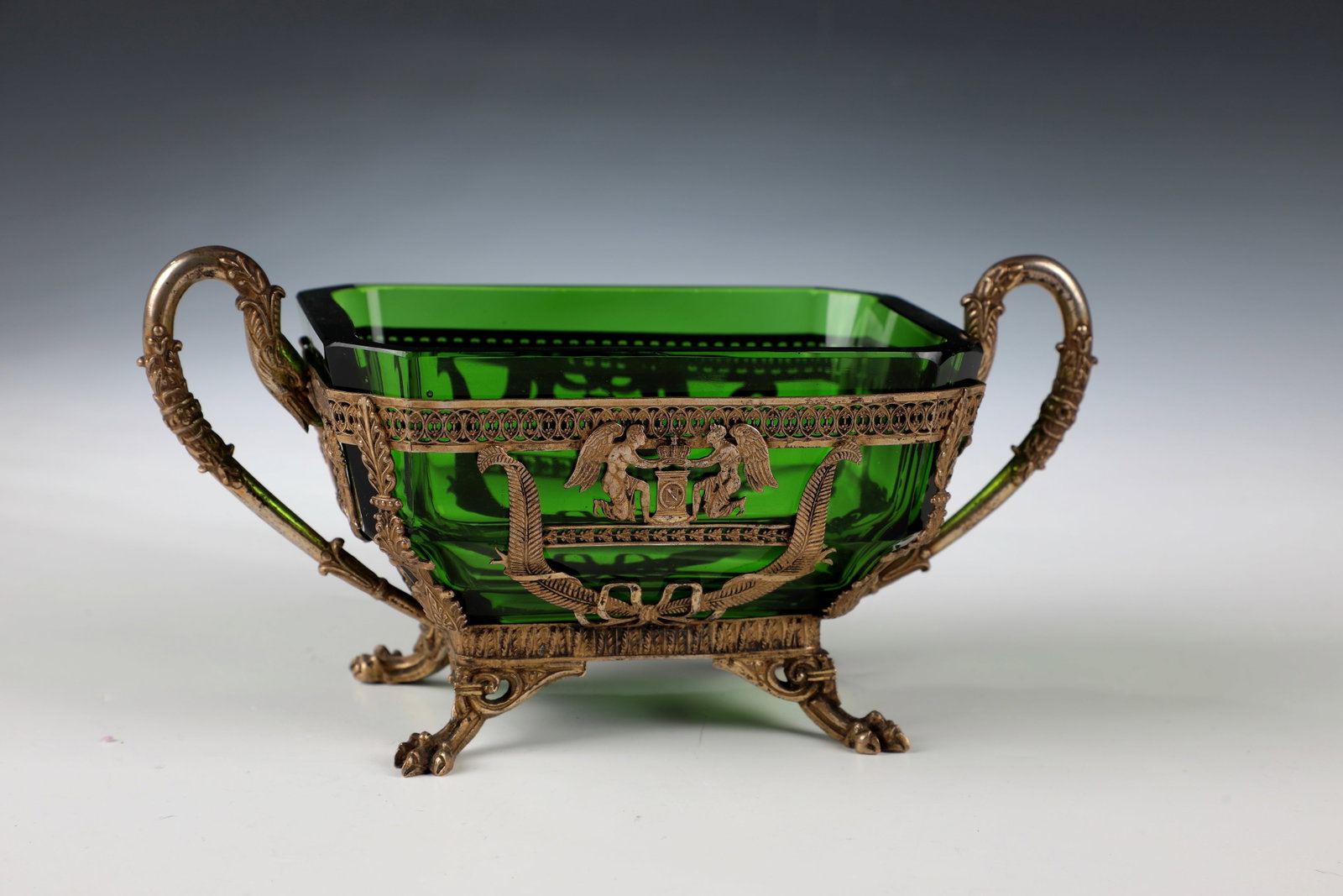 Empire Sugar Bowl: Empire Sugar Bowl France, circa 1815 Rectangular body with beveled corners of transparent, deep green glass supported by four intricately curved paw feet. The filigree, openwork metal mount shows