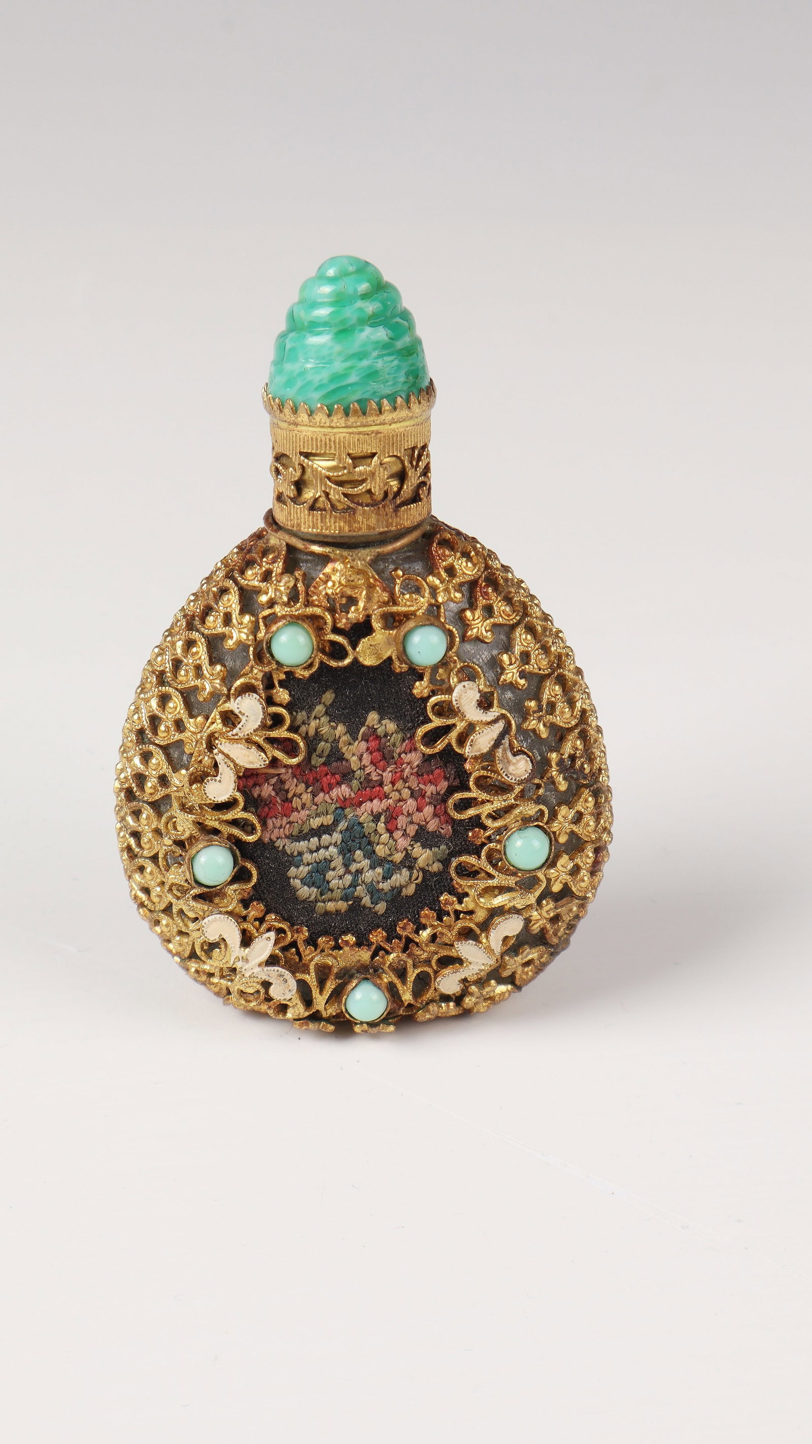 Bottle: Bottle Czechoslovakia, late 19th century Miniature glass vials embedded in a cage made of gilded metal mesh. Central embroidery with floral décor surrounded by five turquoise glass stones. H.
