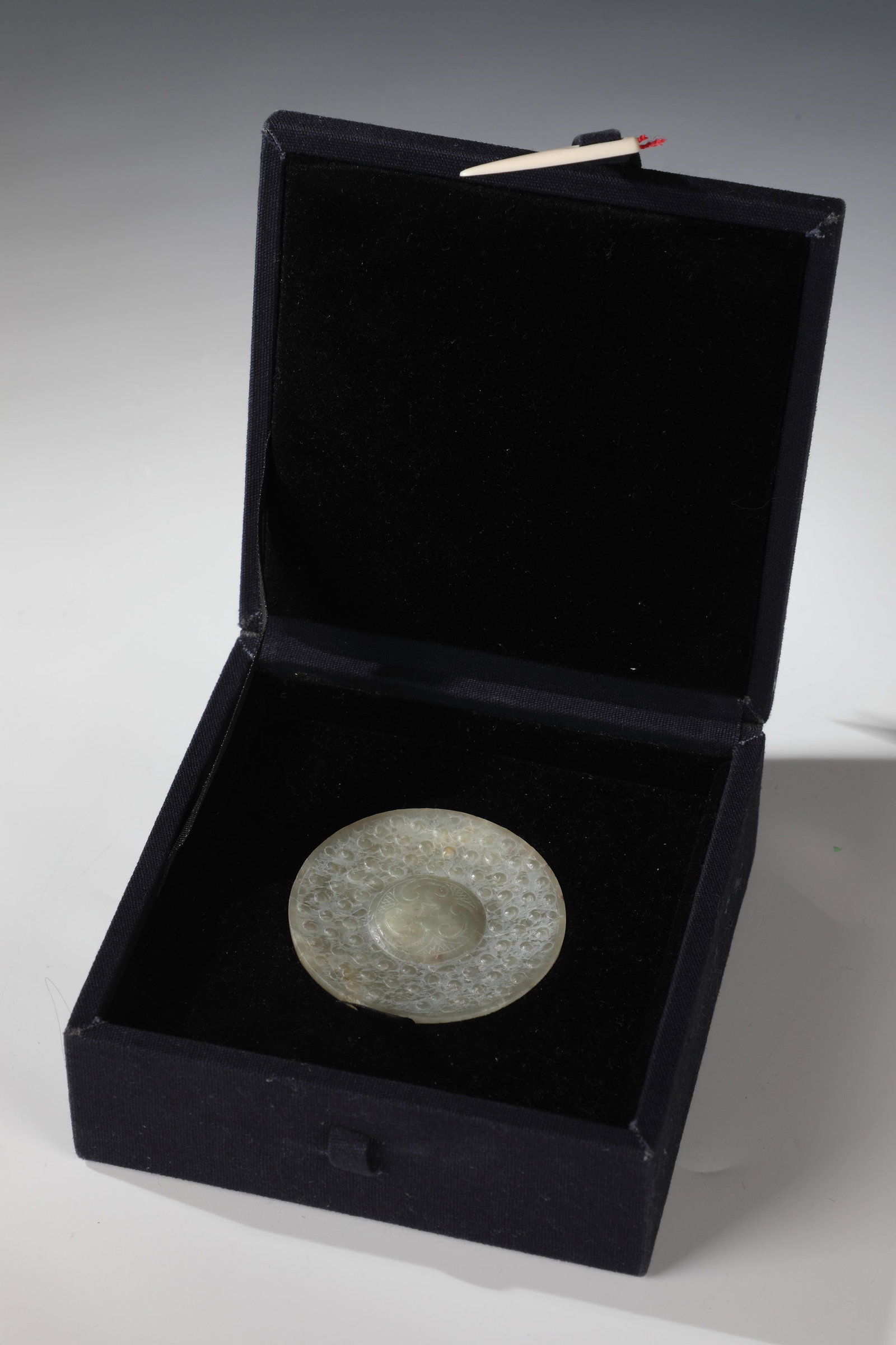 Sword pommel made of jade in archaic style: Sword pommel made of jade in archaic style China, probably 19th century Round and disc-shaped sword pommel made of solid light green jade with straight outer rim. The front side with a centrally