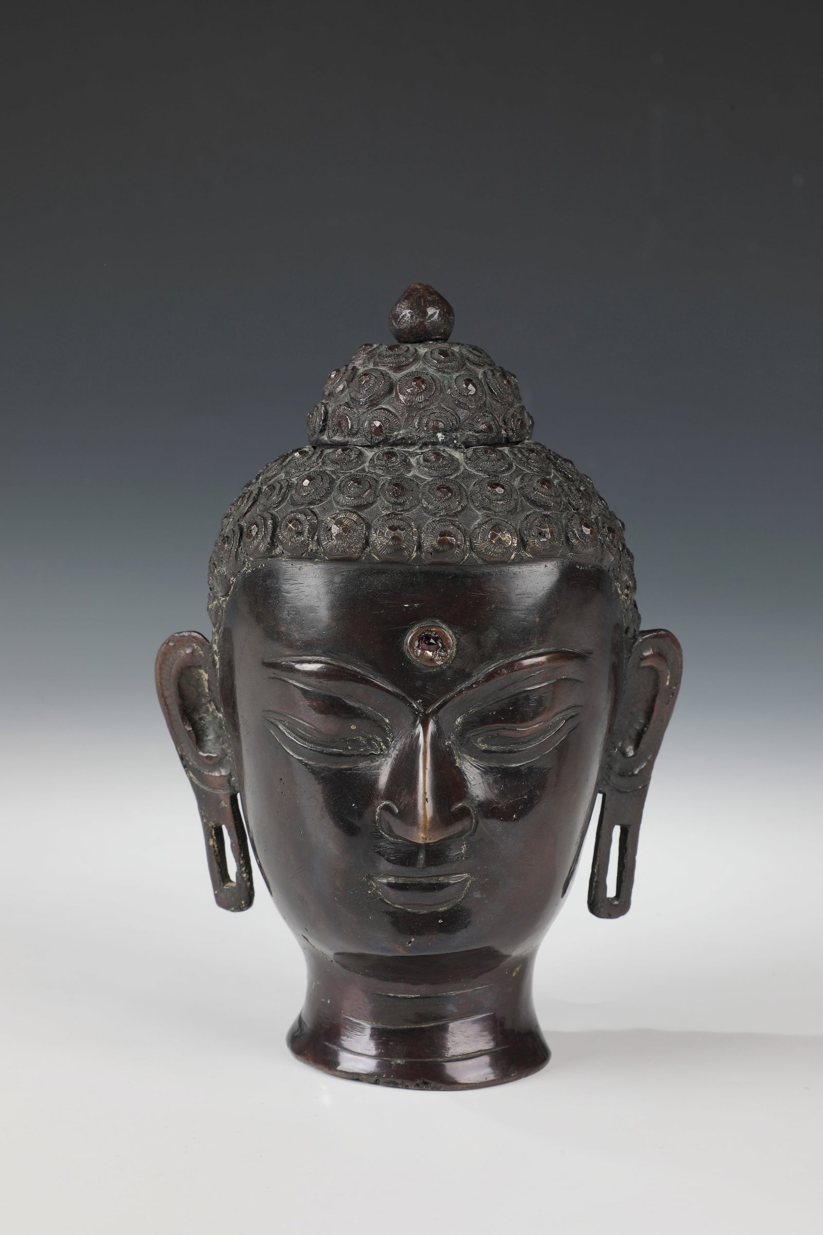 Buddha head in the style of Dvaravati: Buddha head in the style of Dvaravati Thailand, 20th century bronze, based on an ancient model of the Dvaravati style: peaceful, introverted expression; the eyes downcast, introspective. Linear brows 