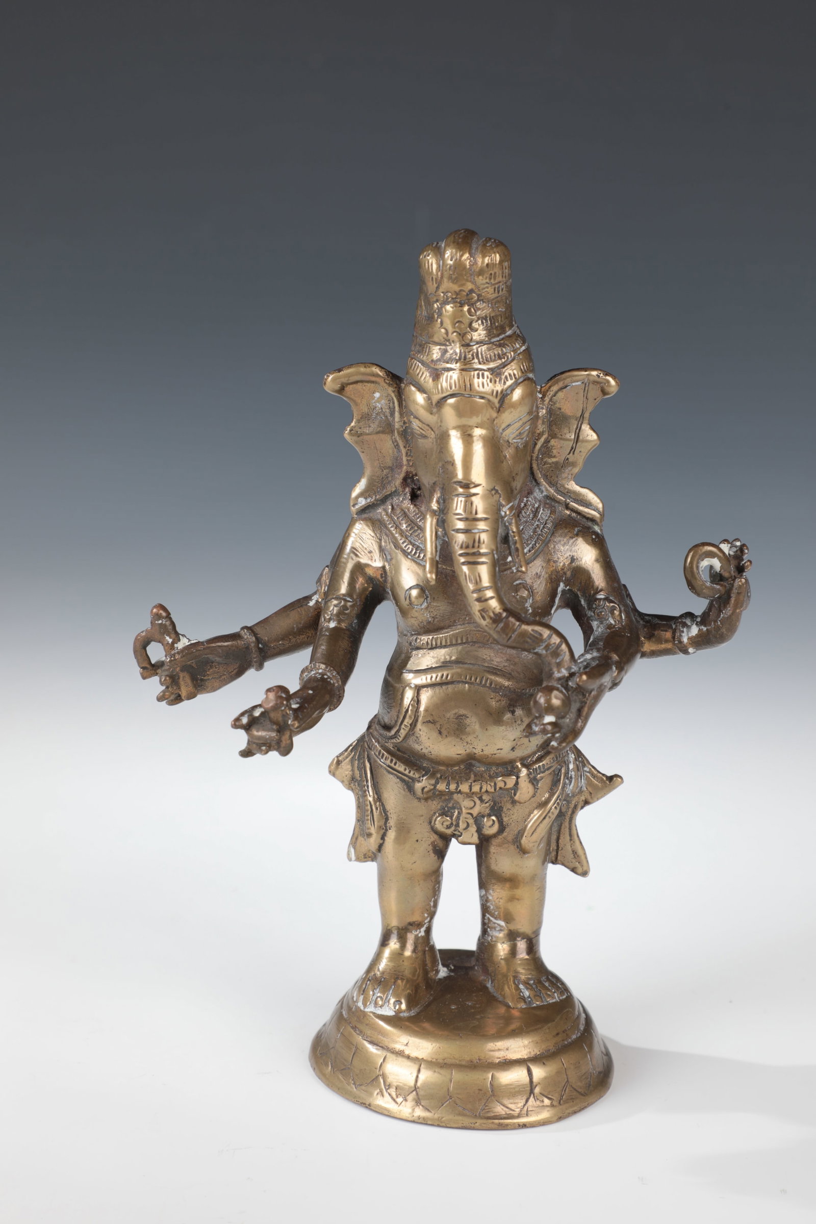 Standing Ganesha: Standing Ganesha India, late 19th century Four-armed Ganesha figure made of bronze, on a round lotus position, holding an attribute in each hand. H. 19.5 cm.