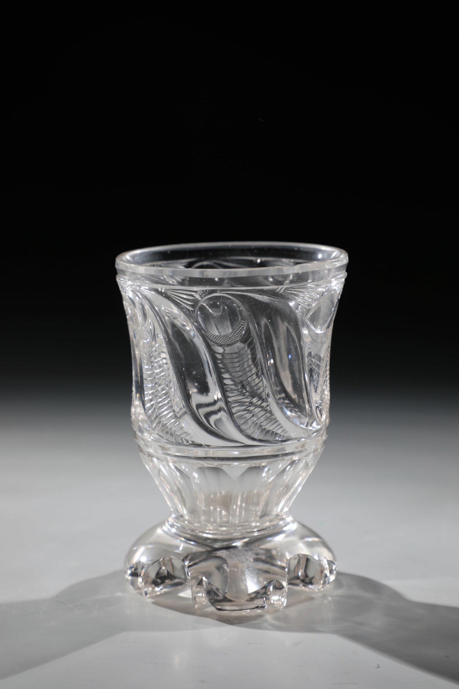 Foot cup: Foot cup Bohemia, 2nd half of the 19th century Colourless, richly cut glass. Offset lip edge chipped. H. 12.5 cm Fußbecher Böhmen, 2. H. 19. Jh. Farbloses, reich schliffverziertes Glas.