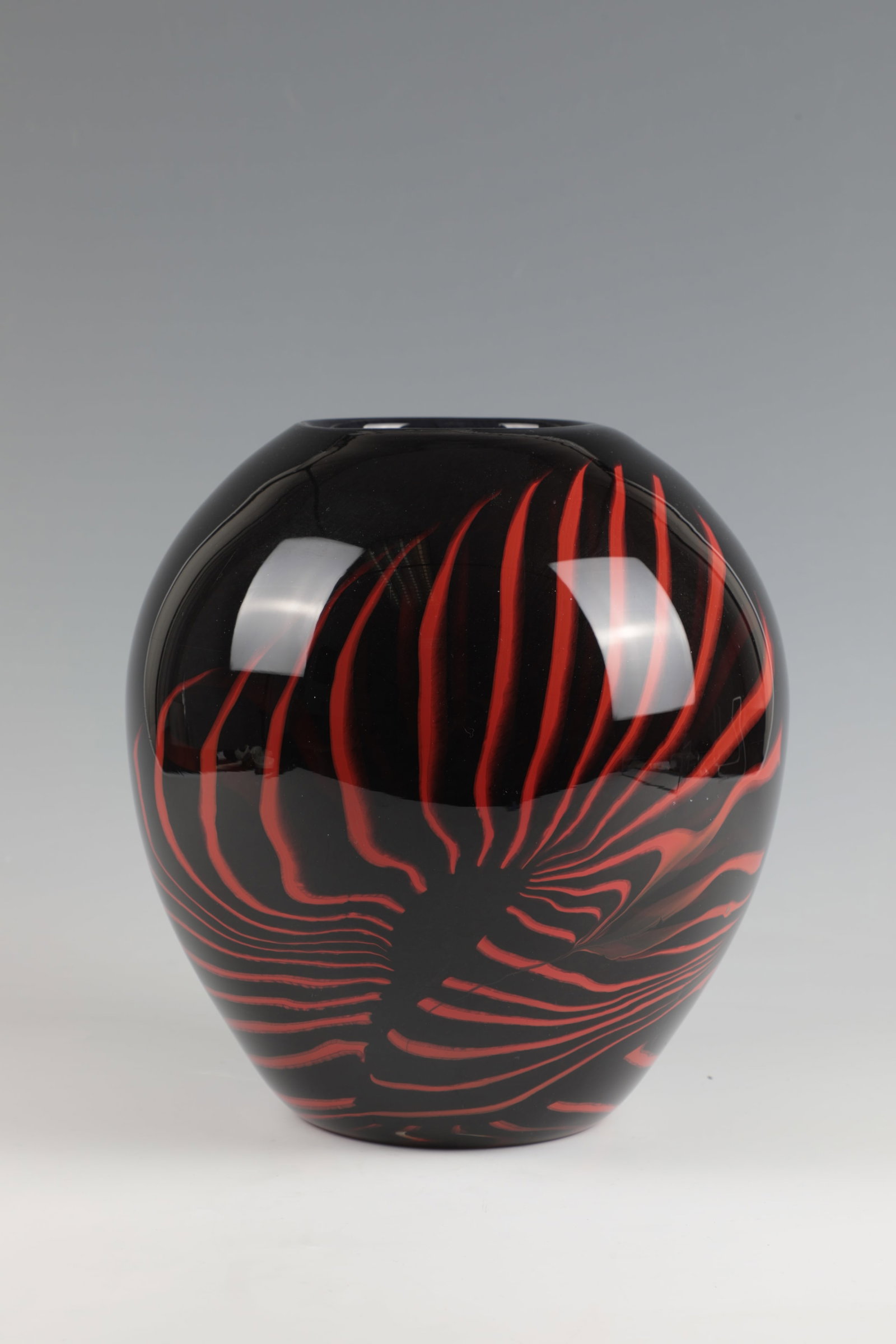 Vase: Vase Mihai Topescu (1956) Colourless glass. Black-violet underpinning. Interlayer deckor made of radially distorted, orange-red glass rods. Signed in engraving on the wall: M. Topescu. H. 24 cm Vase