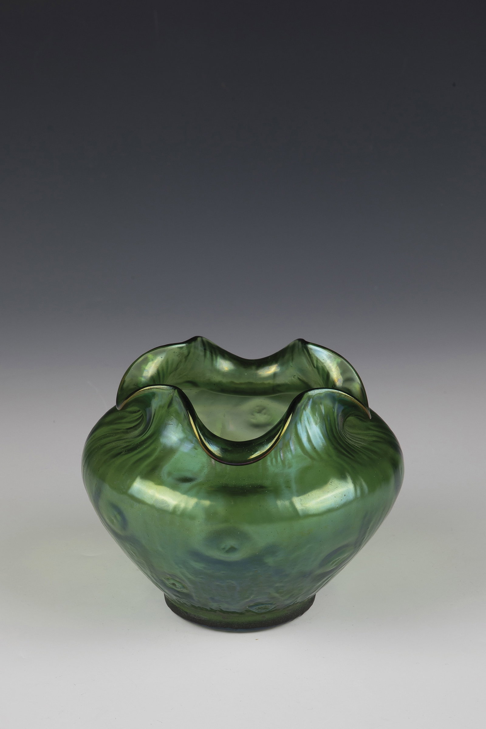 Vase ''Rusticana'': Vase ''Rusticana'' Loetz Wwe., Klostermühle, c. 1899 Green glass, pre-blown in optical form with gnarled structure. Matt iridescent. Muzzle lobed down four times. H. 11 cm. Vase ''Rusticana''