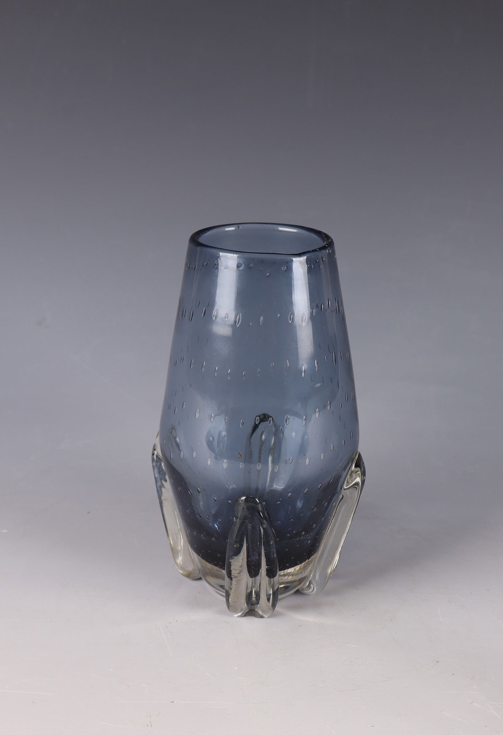 Vase: Vase Gunnel Nyman (design), Nuutajärvi Notsjö, 1953 Colourless thick-walled glass, blue-purple underlay. With regularly pierced air beads. Four appliquéd, colourless legs, freely