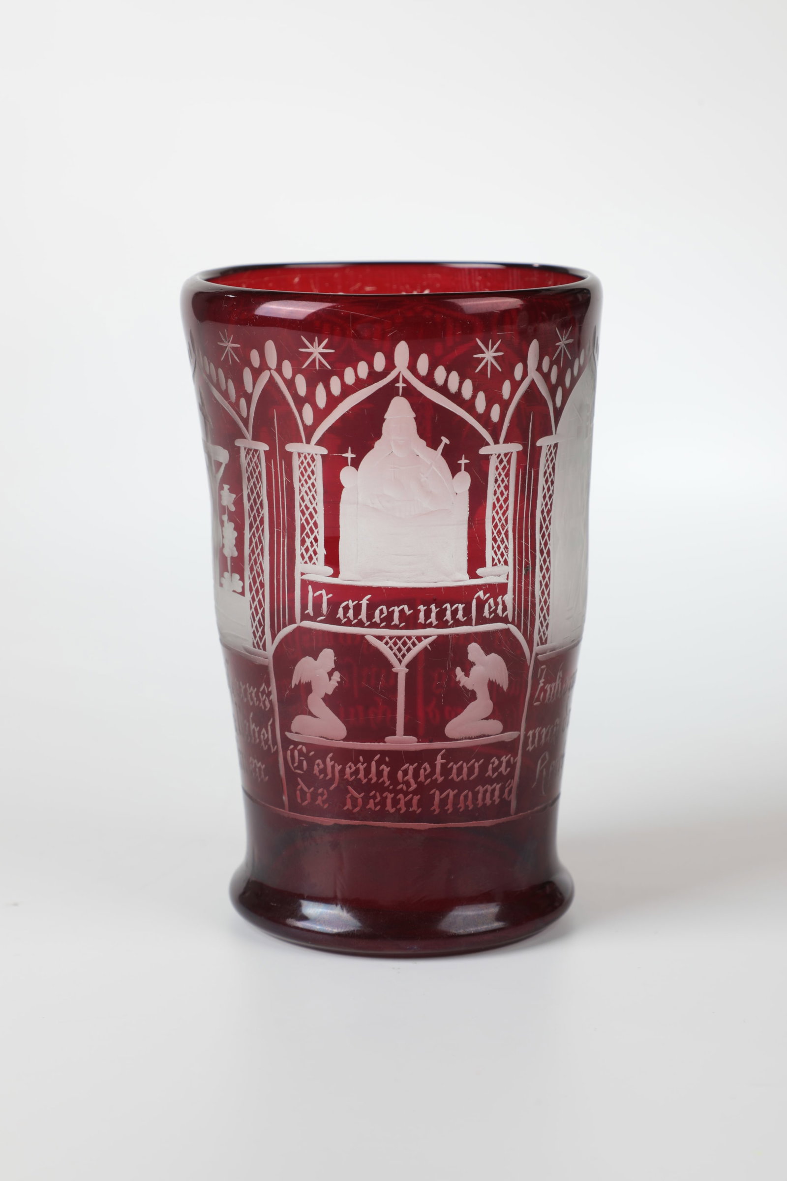 Cup with the Lord's Prayer: Beaker with the Lord's Prayer Bohemia, E. 19th century Colourless, red-glazed glass with scenes cut all around and engraved verses of the Lord's Prayer. H. 13 cm Becher mit dem Vaterunser