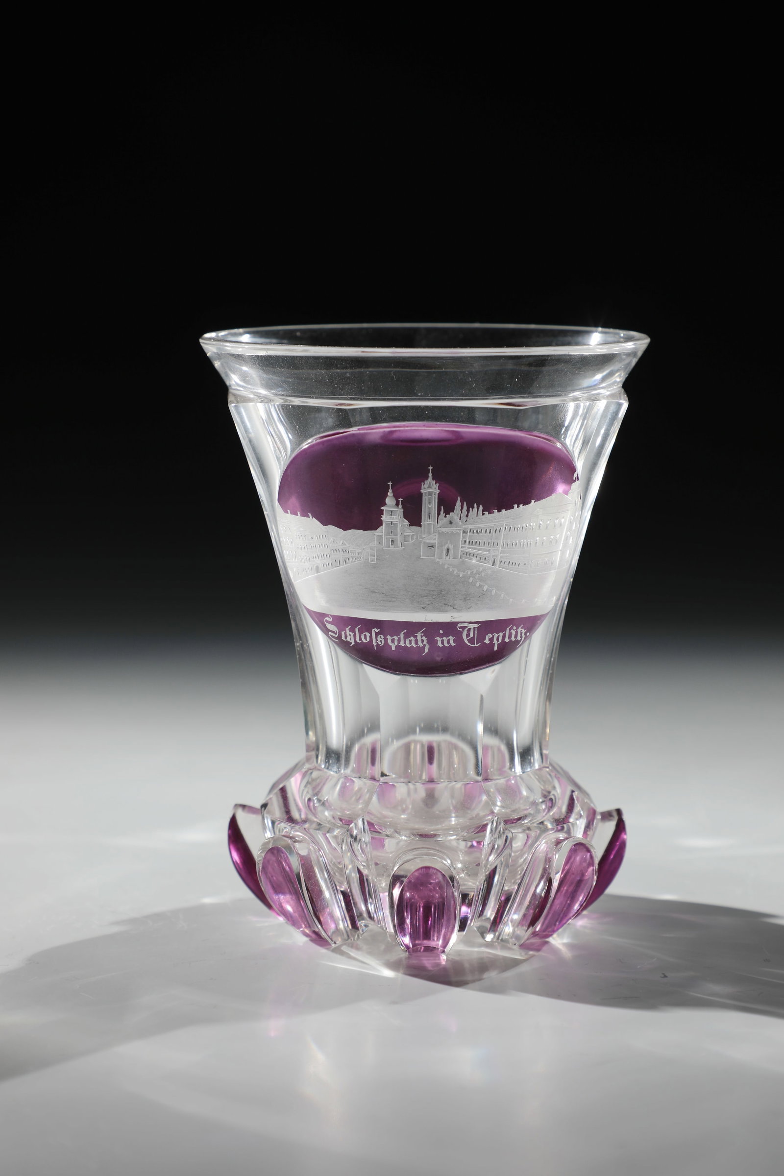 Ranft cup with vedute from Teplice: Ranft beaker with vedute of Teplice North Bohemia, c. 1840 Colourless glass. Back with notched grinding. Ranft with highly polished, partly violet glazed arch ornaments. Frontal on the multi-faceted