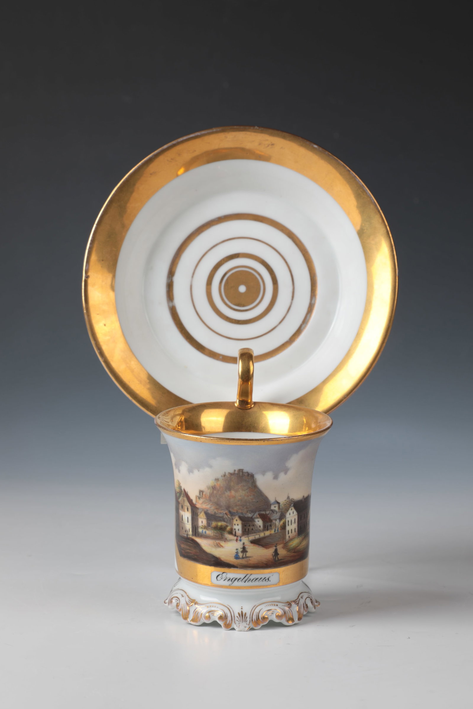 Cup and saucer: Cup and saucer Bohemia, 19th century porcelain. Cup on relief rocaille base. Ko0nic, slightly swinging upwards wall with rich polished gold staffage, gilded lip rim and curved ear handle. On the