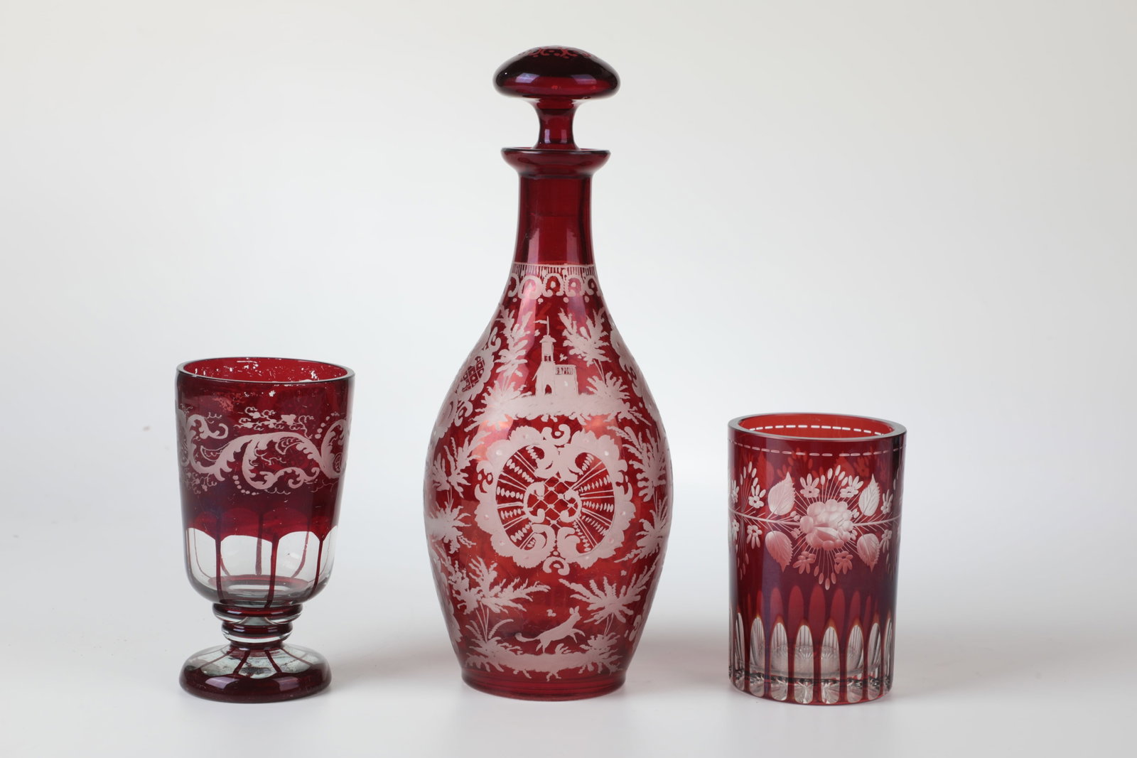 Carafe with stopper and two cups: Carafe with stopper and two cups Bohemia, E. 19th century Colourless, red lacquered glass with richly engraved decoration. H. 11,5 bios 21 cm Karaffe mit Stöpsel und zwei Becher Böhmen, E.