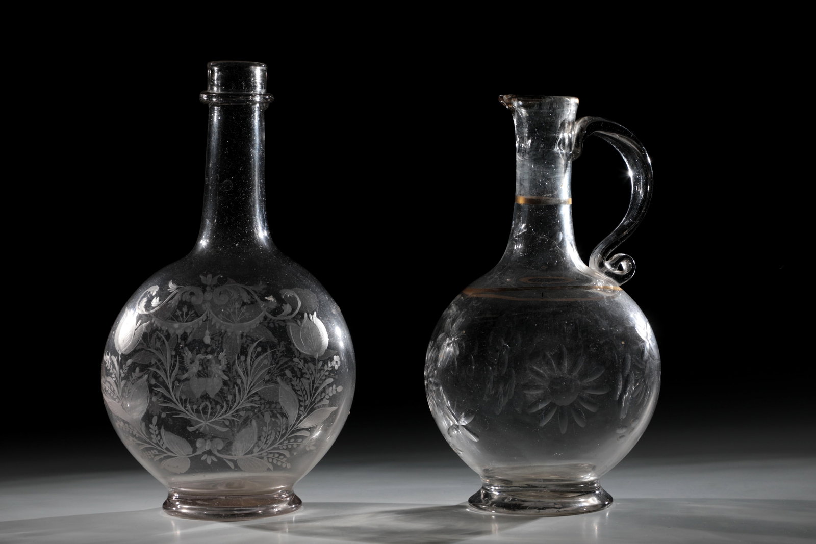 Carafe and handle carafe: Carafe and handle carafe Giant Mountains, 18th century Colourless glass with tear-off. Frontal on the wall flattened on both sides flanked by tulips and palm branches double-hearted with turtle
