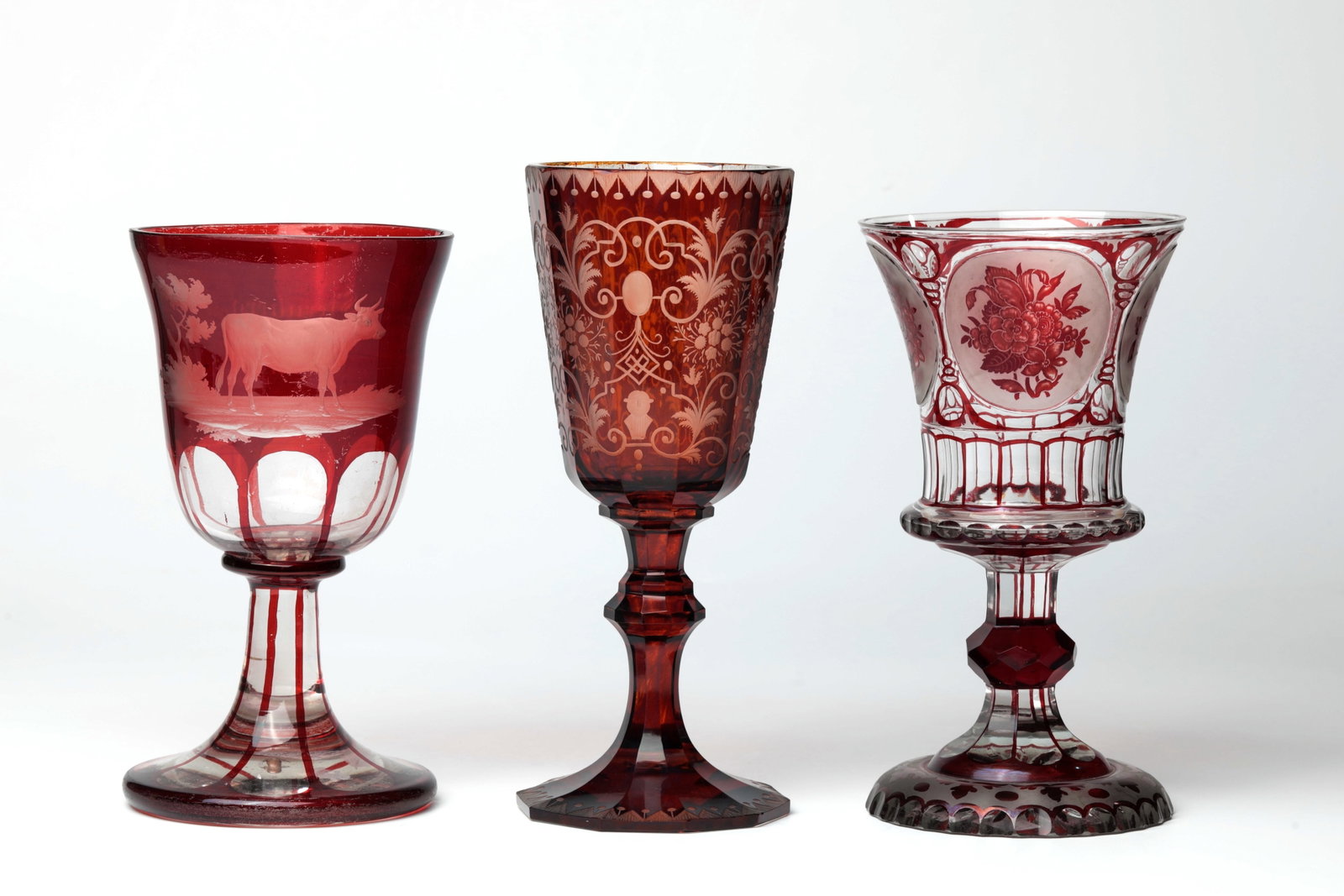 Mixed lot of three trophies: Mixed lot of three goblets by the workshop of Egermann or Carl Goldberg, 2nd half of the 19th century. Different decors: cut or glazed floral decoration as well as cut depiction of a cow with