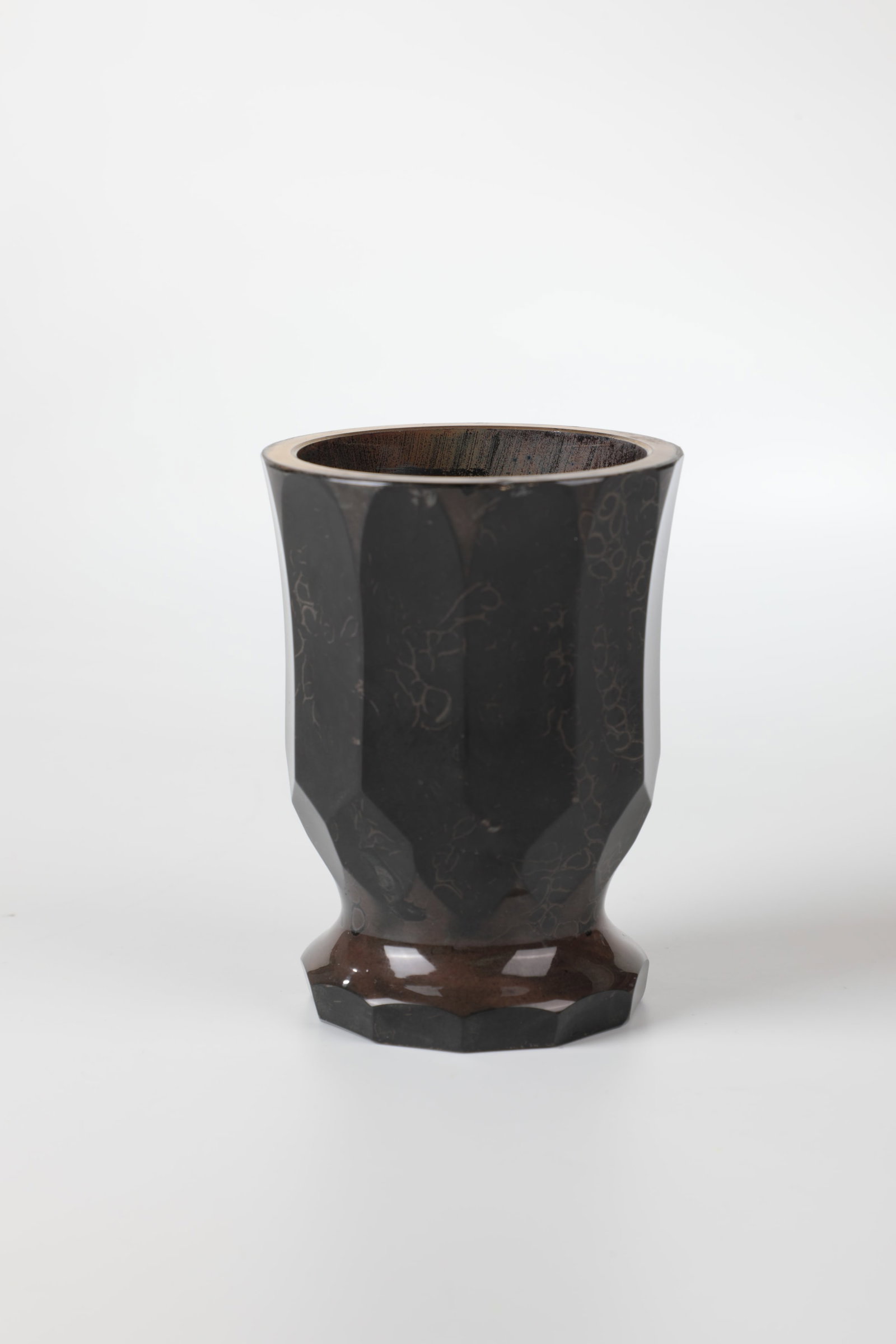 Foot cup made of stone glass: Foot cup made of stone glass, Bohemia, M. 19th century, deep dark glass. The edge of the stand and bell-shaped wall faceted. Gold-plated lip rim chipped. H. 10.5 cm Fußbecher aus Steinglas
