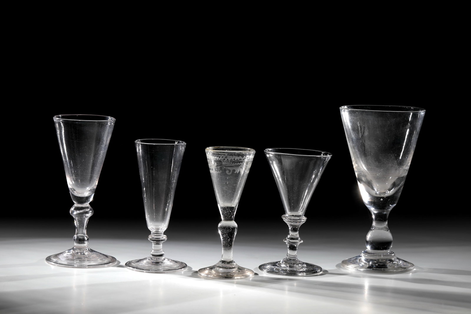 Mixed Lot of Five Chalices: Mixed lot of five goblets, German, 18th / 19th century, colourless glass with tear-off. Disc feet, two with the edge turned downwards. Baluster shafts and conically widened domes. one with a slid