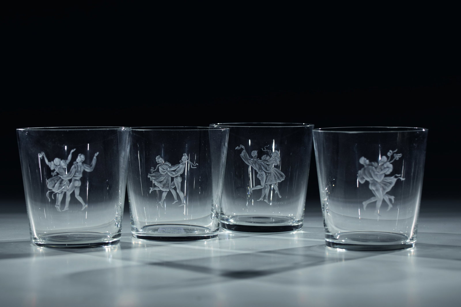 Four beakers with engraving: Four beakers with engraving Probably Czechoslovakia, 1957 Colourless glass with frontal decoration engraved in a deep cut: Dancing couples. Signed (artist's monogram) and dated below the depiction: