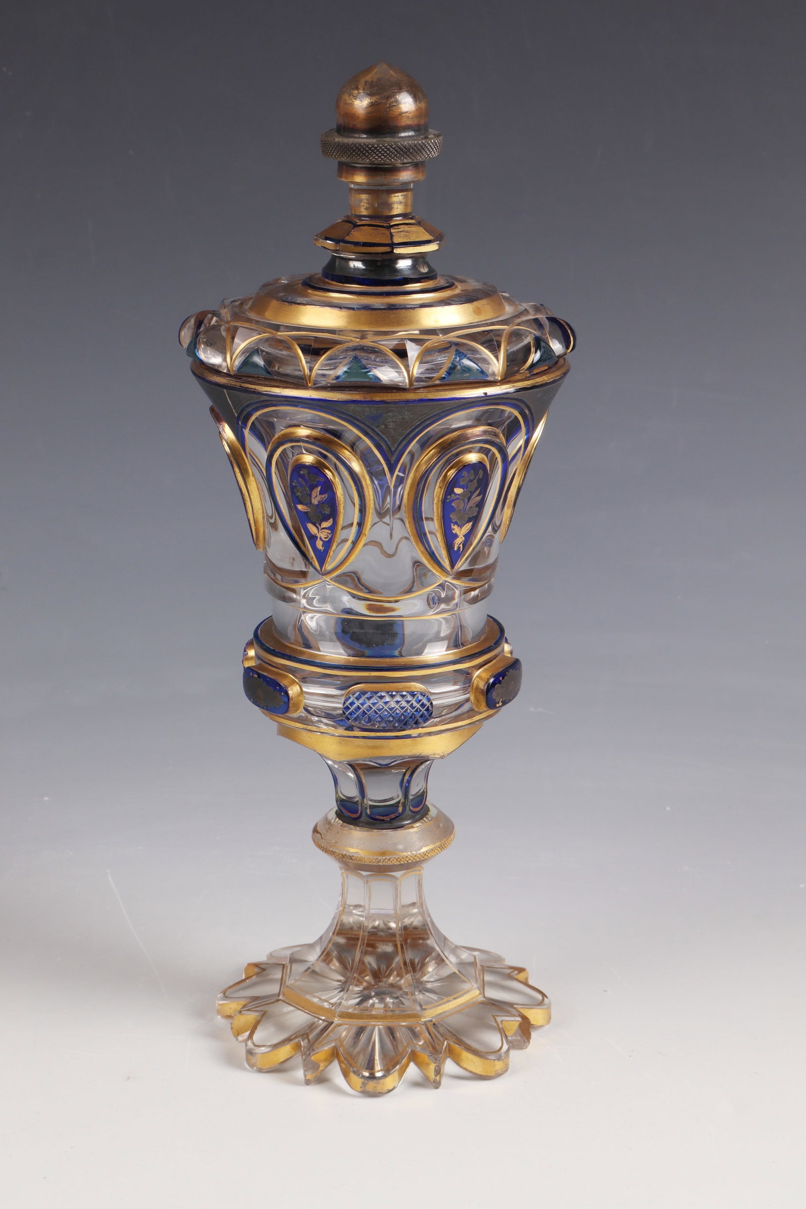 Lidded cup: Lidded goblet North Bohemia, c. 1840 Colourless glass, partly with cobalt blue overlay. Passively sharpened foot. Peeled shaft with disc nodus. Attachment of the bell-shaped cuppa with six high-cut