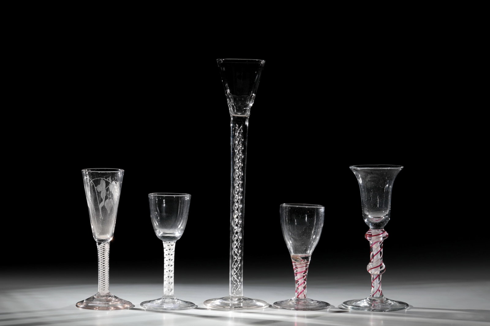 Mixed lot of five thread glasses: Mixed lot of five thread glasses Netherlands or England, 18th century Colourless glass with tear-off. Disc base, shaft with partly white, partly with ruby glass or hollow threads. Cups with sliced