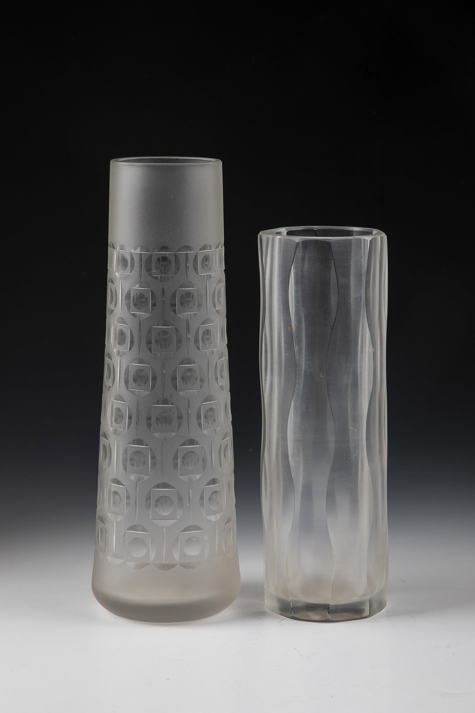 Two vases: Two vases Hanns Model, second half of the 20th century Colourless glass with serrated edge and with rough-matt and partly polished carved structures. A vibro-engraved vase monogrammed ''HM''. H. 21 or
