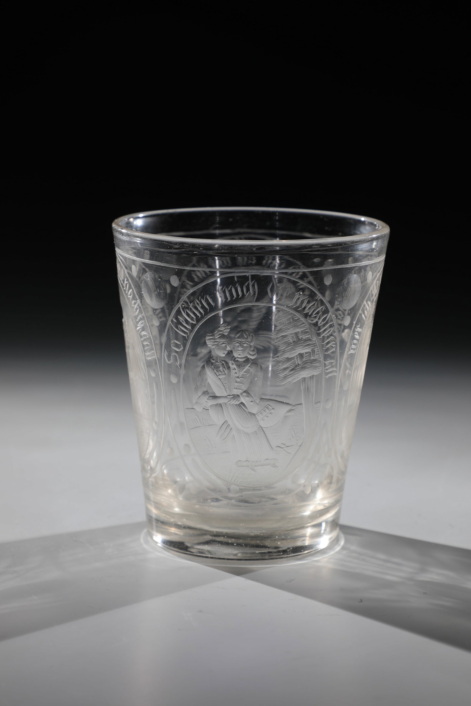Mug with erotic allegories: Beaker with erotic allegories Bohemia, 18th century Colourless glass with polished tear-off. On the conically widened wall, four high ovals with cut allegories. H. 12.5 cm Becher mit erotischen Allego
