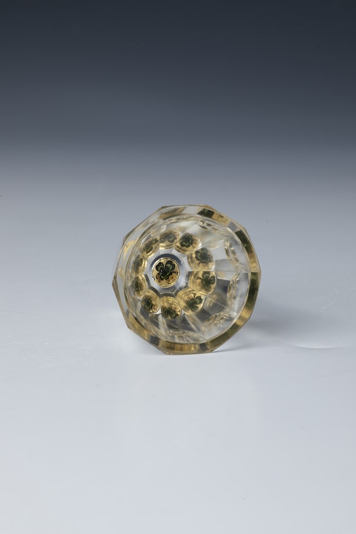 Prism cup: Prism cup Bohemia, c. 1900 Widened, faceted walls, colourfully painted clover leaf on the underside of the bottom in front of a gold background. H. 5.3 cm Prismenbecher Böhmen, um 1900