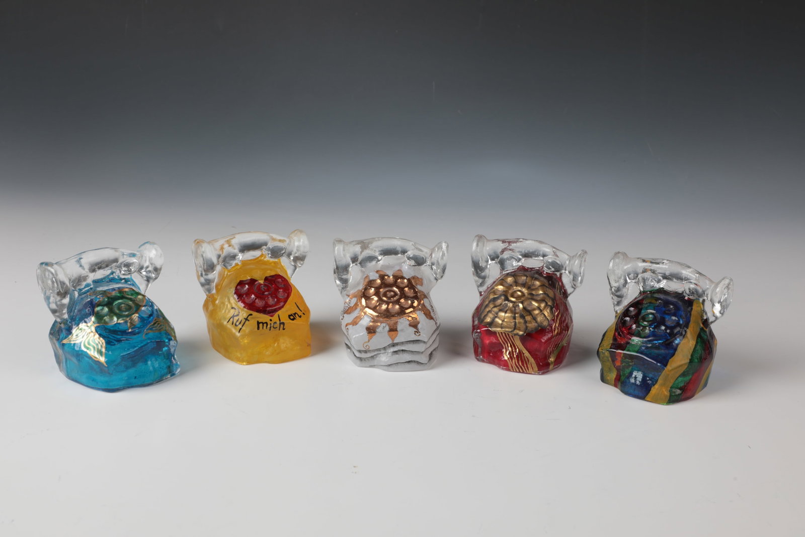 5 Miniature Phones: 5 miniature telephones Atelier Eisch, Frauenau, around 2008 Colourless glass, with various, polychrome decors. Two with inscription and date: Eisch 08 E.E. H. 7.5 cm. 5 Miniatur-Telefone Atelier