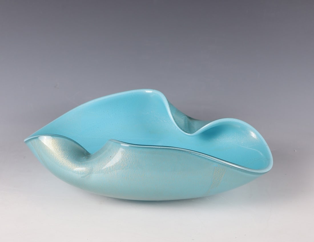 Shell: Murano bowl, c. 1960/65 Light blue glass, colourless overlay. Between the layers, décor made of burst gold foil melting. H. 9.5 cm; L. 32.5 cm. Schale Murano, um 1960/65 Hellblaues Glas, farblos