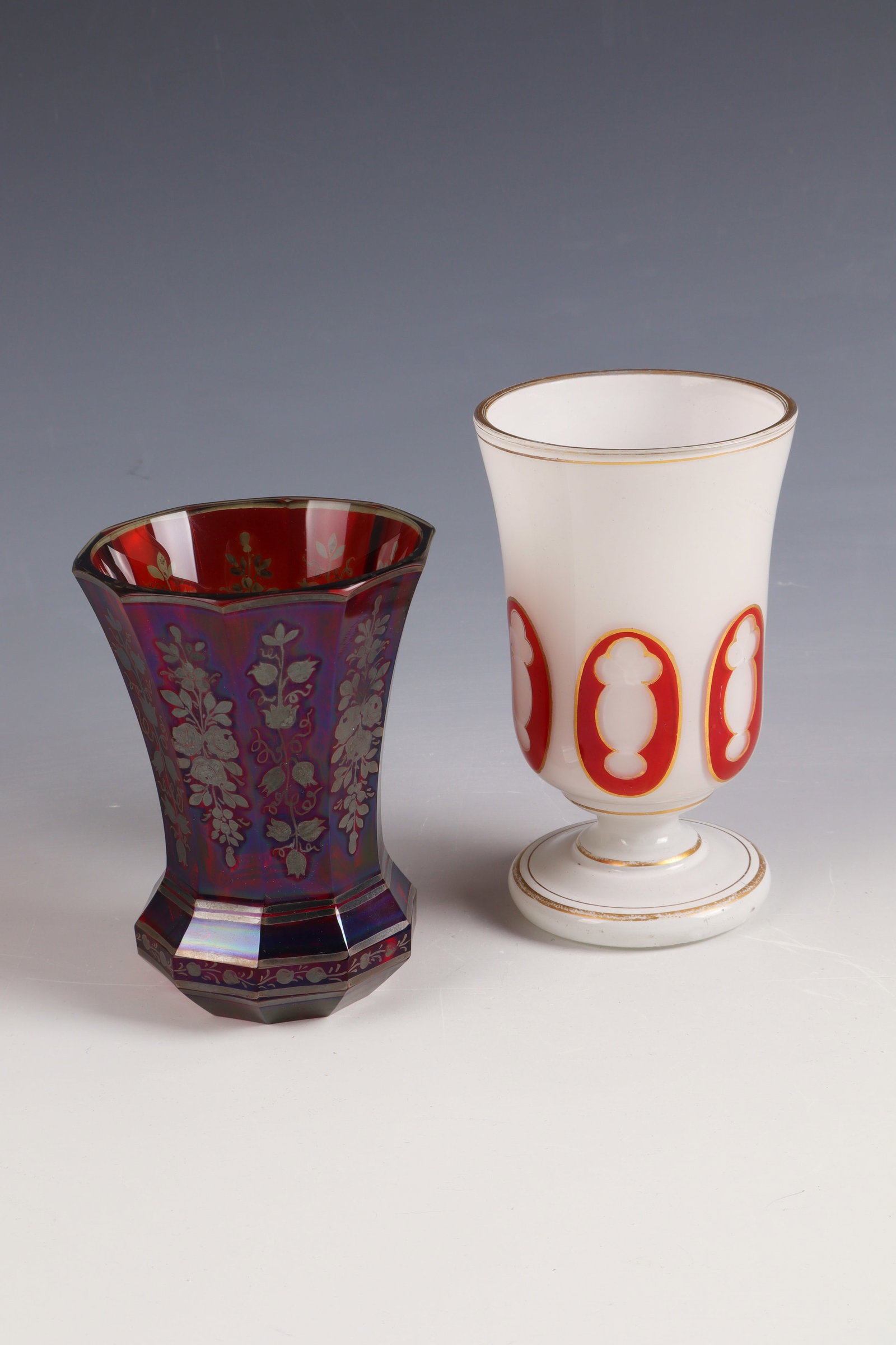 Foot cups and mugs: Foot cup and mug Bohemia, mid-19th century Colourless, red glazed, faceted glass with area-filling, floral decoration in silver. H. 12 cm. Colourless glass with tin enamel overlay, gold line