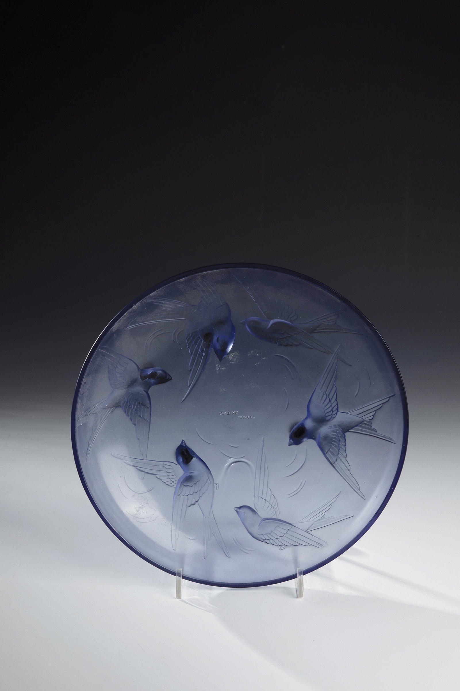 Shell: Bowl Marius Ernest Sabino, Paris, c. 1930 Blue glass, pressed into the mold. On the underside, strongly reliefed decoration: six swallows. In the mirror inscribed: SABINO PARIS (pressed up). D. 29.5