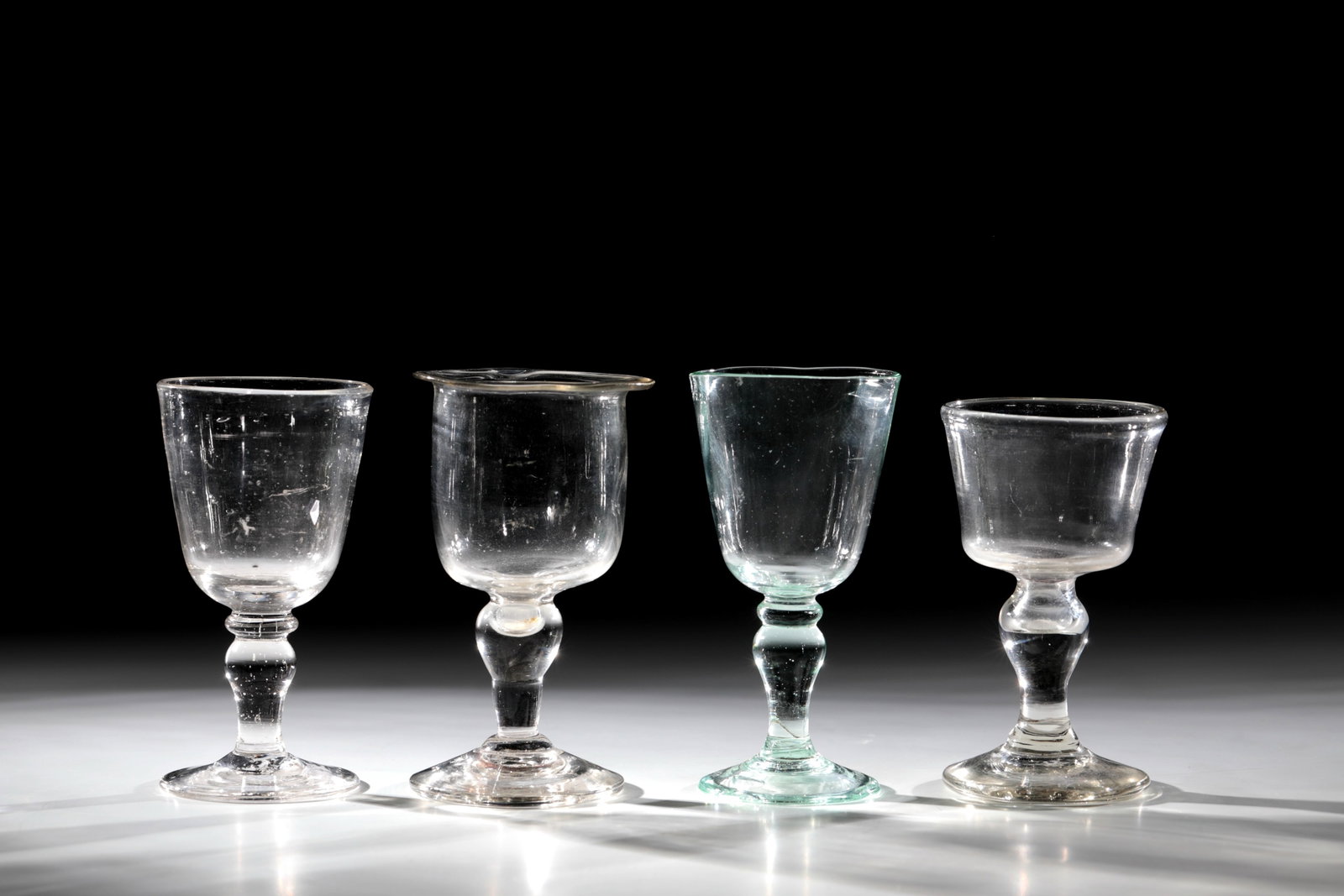 Mixed Lot of 4 Oil Cups: Mixed lot of 4 oil goblets South German, probably Black Forest around 1800 Colorless, partly greenish glass with tear-off. Disc base, baluster shaft, one with almost cylindrical cuppa and folded