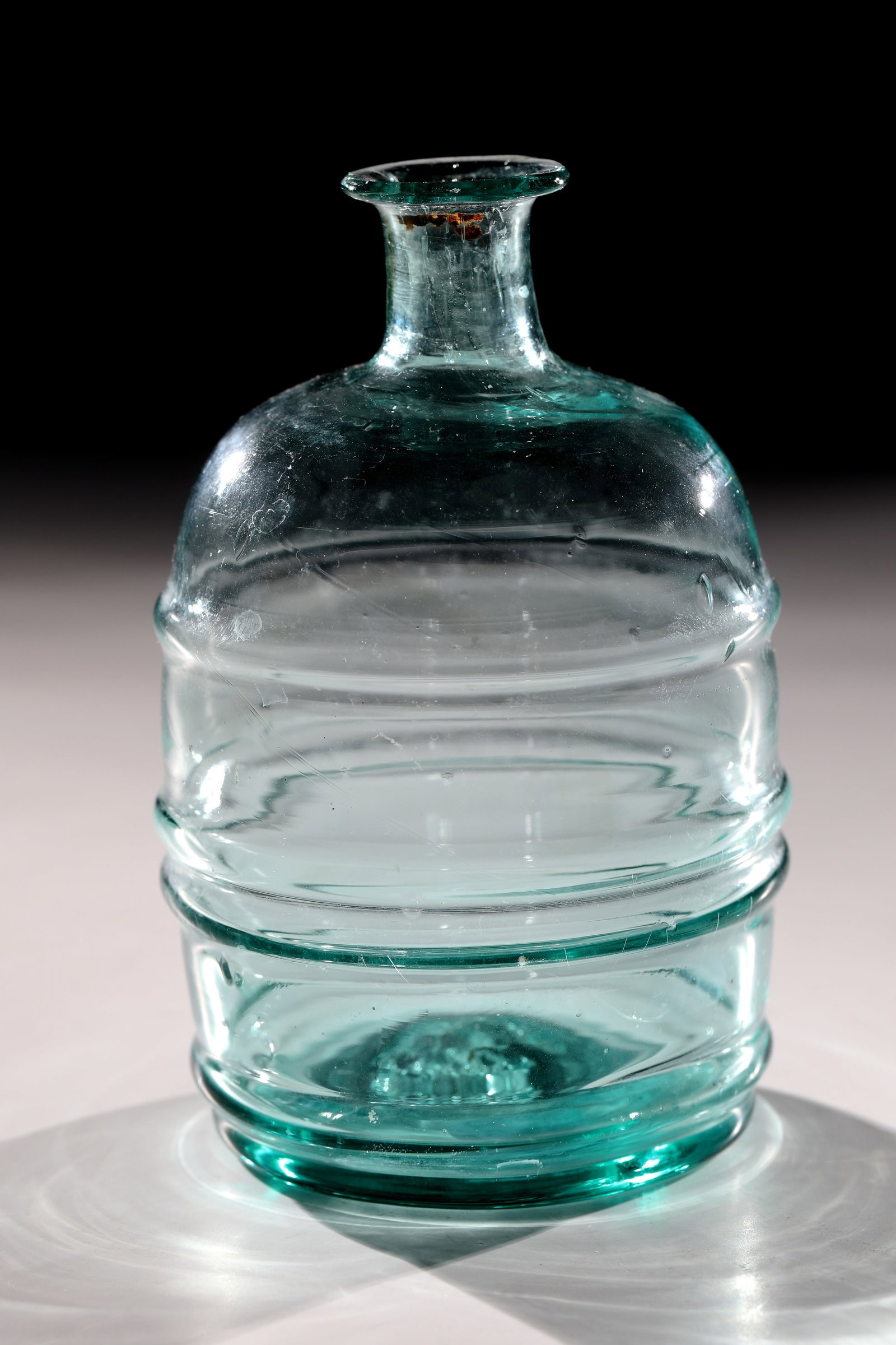Small bottle: Small bottle 18th / 19th century. Light green glass with tear-off. Quadruple compressed wall. Tubular neck with protruding muzzle edge. H. 12 cm Kleine Flasche 18. / 19. Jh. Hellgrünes Glas mit A