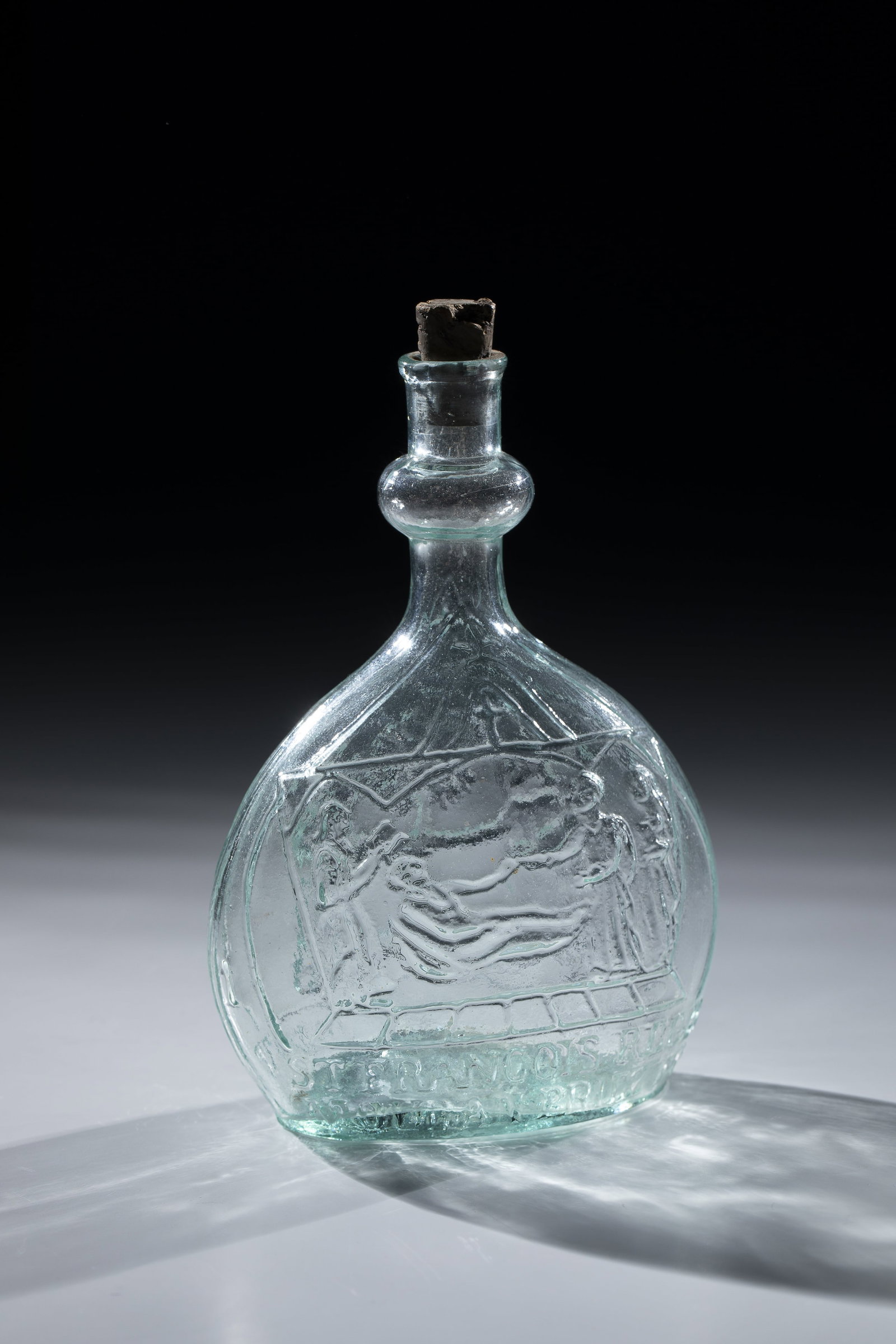 Pilgrim's bottle depicting Saint François Régis: Pilgrim's bottle depicting Saint François Régis France, 19th century Light green, shape-blown glass. On the pouch-shaped wall religious representations and inscriptions: ''ST. FRANCOIS REGIS