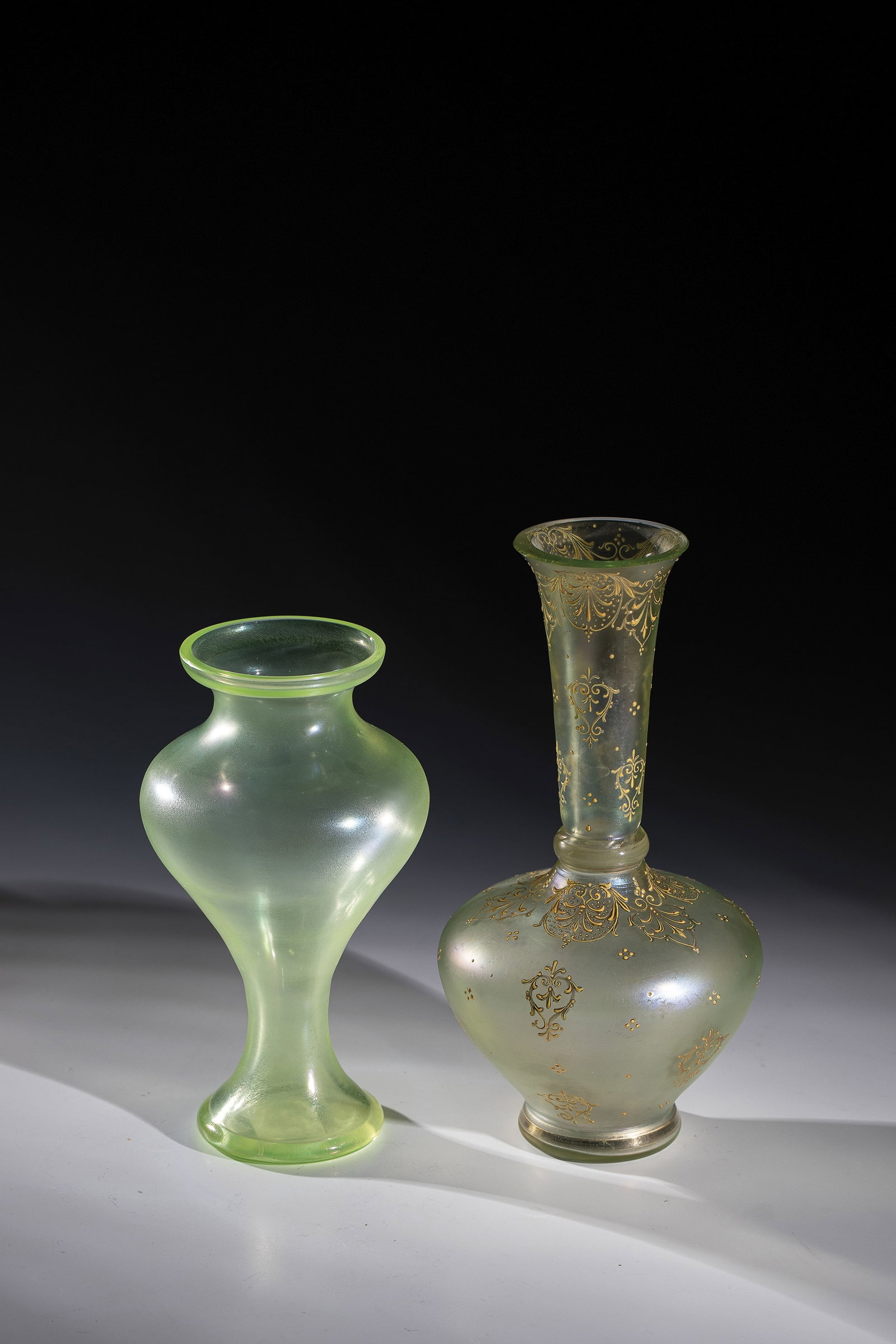 Two vases: Two vases Loetz Wwe., Klostermühle, 1910 Light green uranium glass. A vase with all-round decoration in relief and polished gold painting: stylized foliage. Iridescent. H. 18.5 or 22.5 cm. Zwei