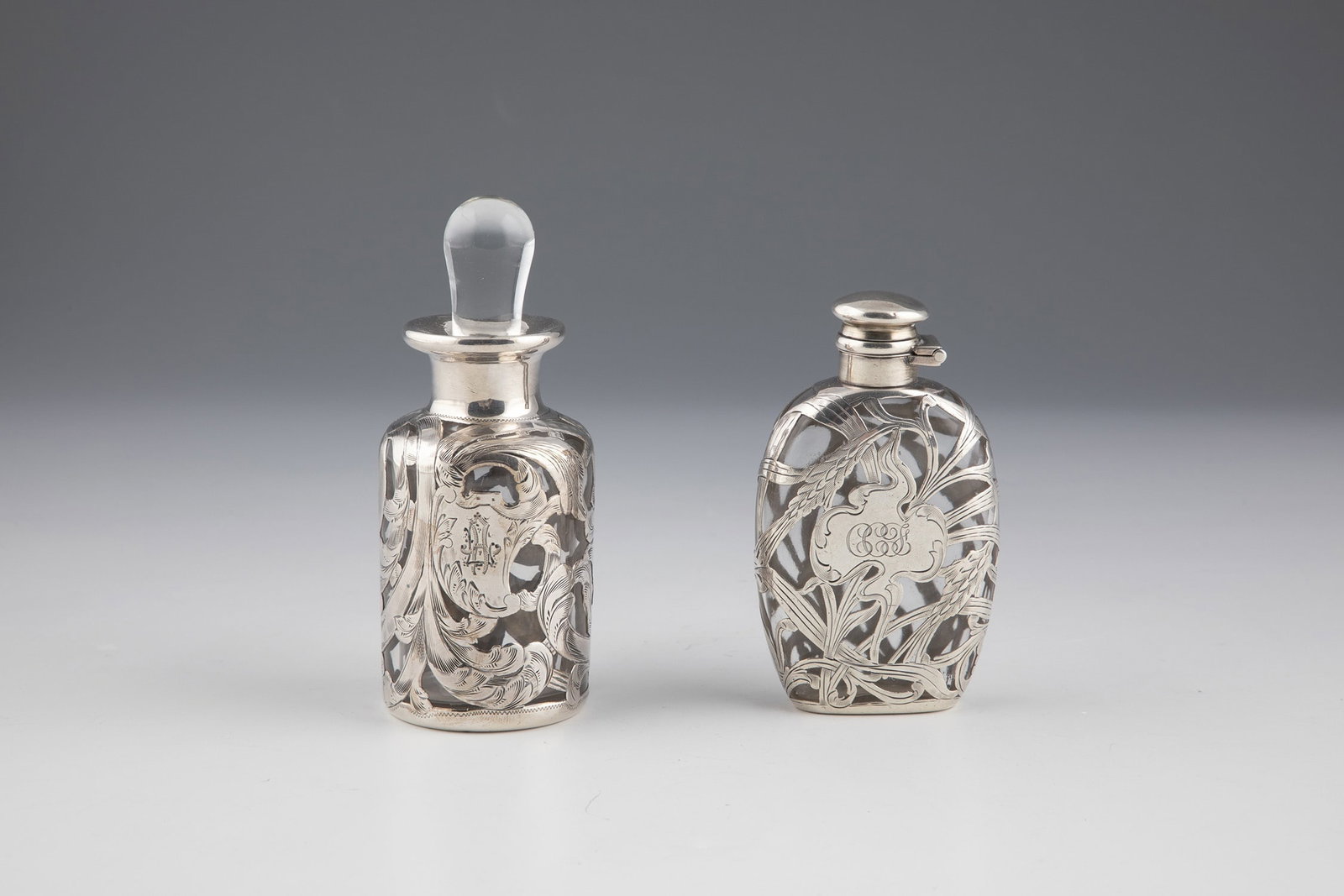 Two bottles with galvanized fine silver decoration: Two flacons with galvanized fine silver decoration Colorless glass with florally worked glavanized fine silver decoration, one bottle with the initials ''CCF''. Silver stamped with ''SOLID SILVER''