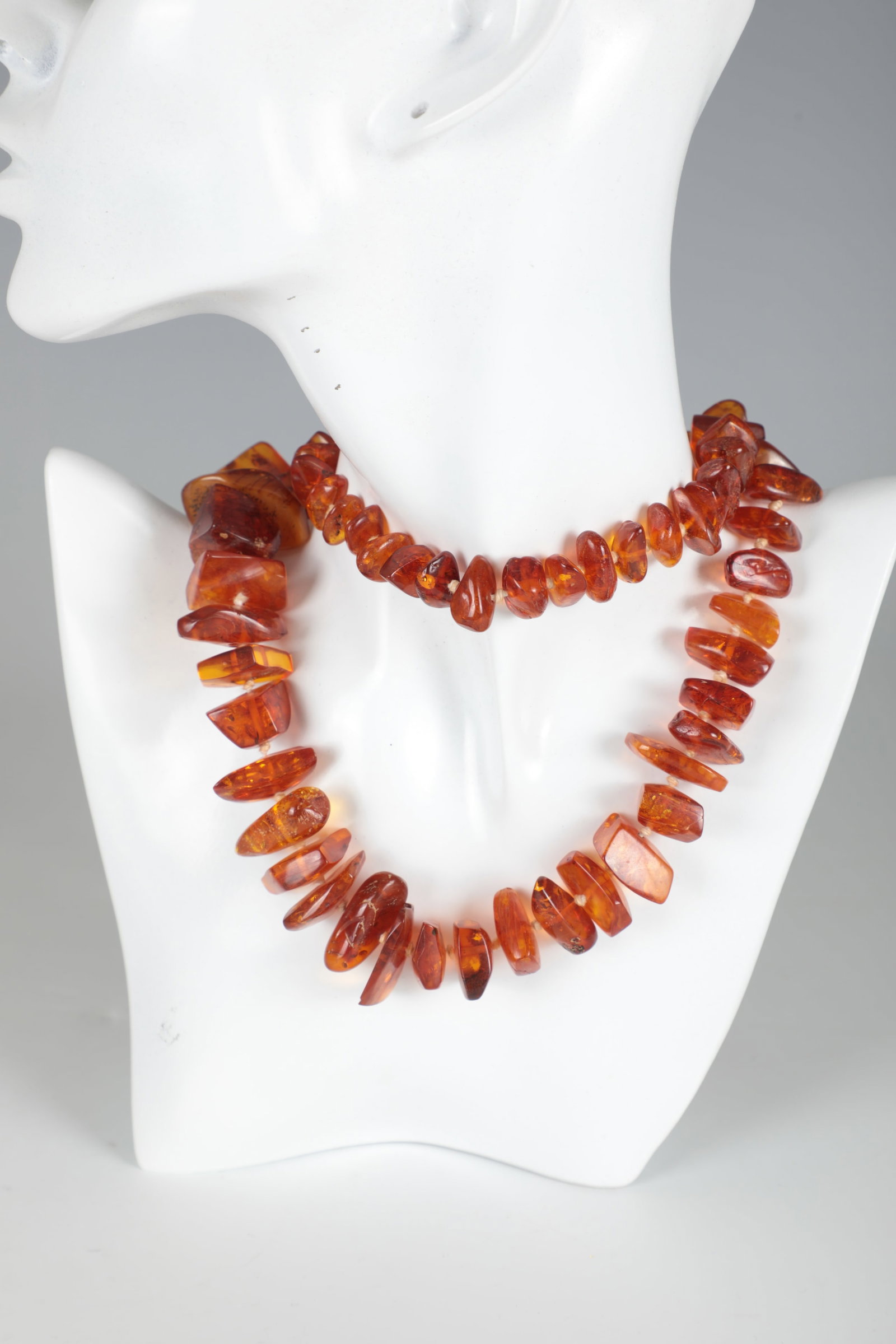 Amber Necklace: Amber necklace of Baltic origin, natural, angular, arranged in size and individually knotted. Length approx. 43 cm; weight approx. 112.10 g. Bernsteinkette Baltische Herkunft, naturbelassen, kantig