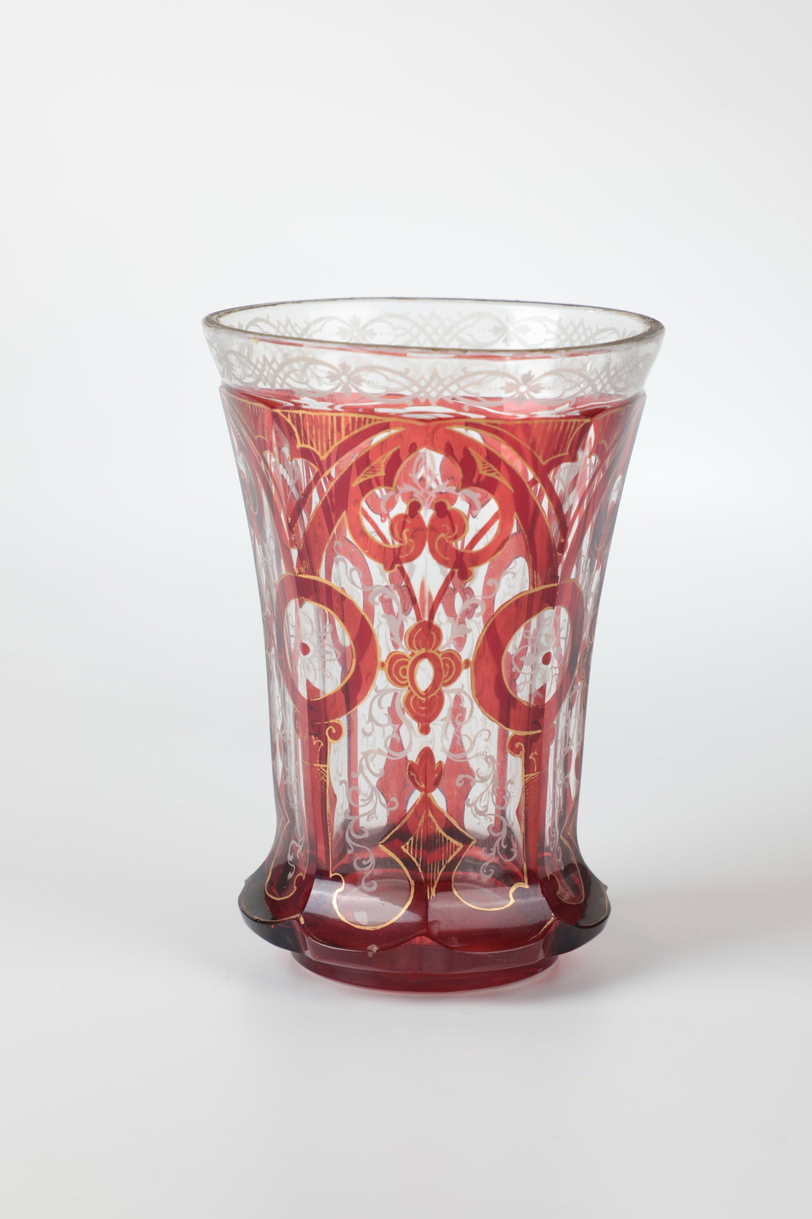 Souvenir Mug: Souvenir cup Bohemia, M. 19th century Colourless, partly red-glazed glass with gold-contoured ornamental decoration and white enamel painting: flourishes and tendrils. Inscription engraved in the