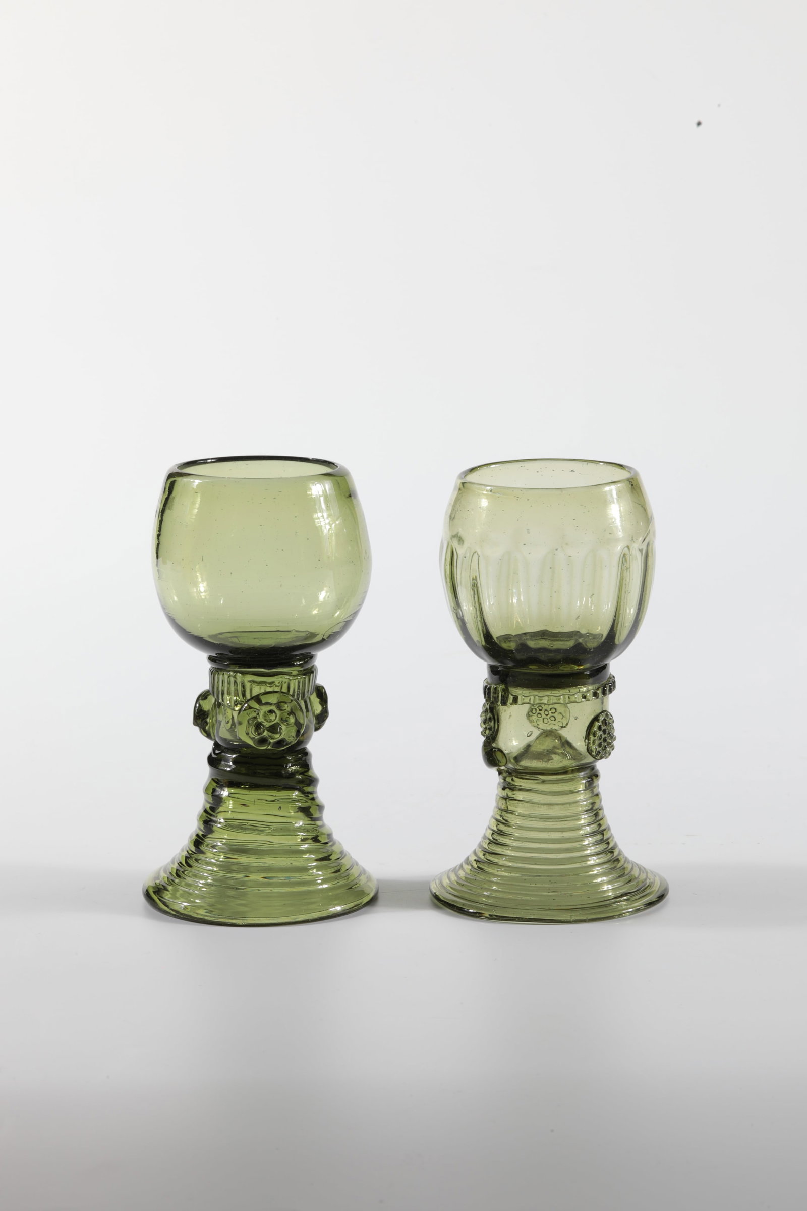Two Romans: Two Romans German, 19th century Green glass with tear-off. Ribbed trumpet foot. Stock with appliquéd berry nubs. A cuppa ribbed. H. 12 or 12.5 cm Zwei Römer Deutsch, 19. Jh. Grünes