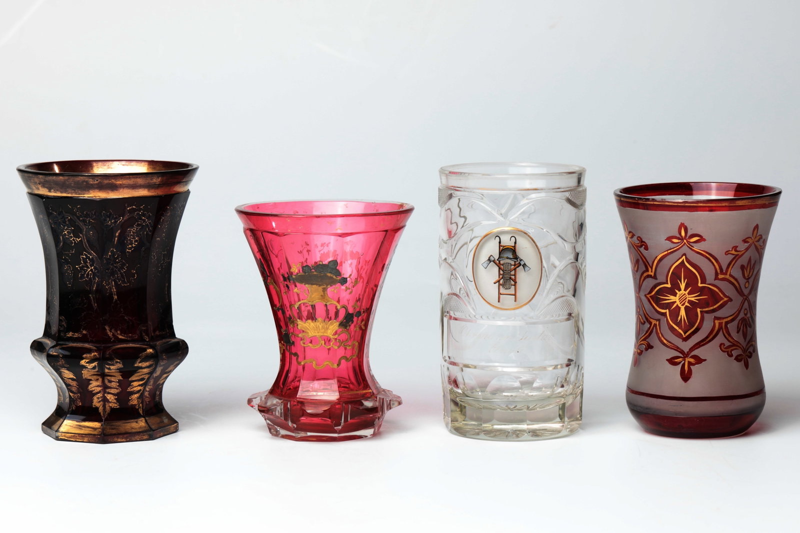 Mixed Lot of Four Glasses: Mixed lot of four glasses, 19th century, colourless glass, partly red and pink, glazed with gold and enamel painting. A lip rim restored. H. 11- 13 cm Konvolut vier Gläser 19. Jh. Farbloses Glas