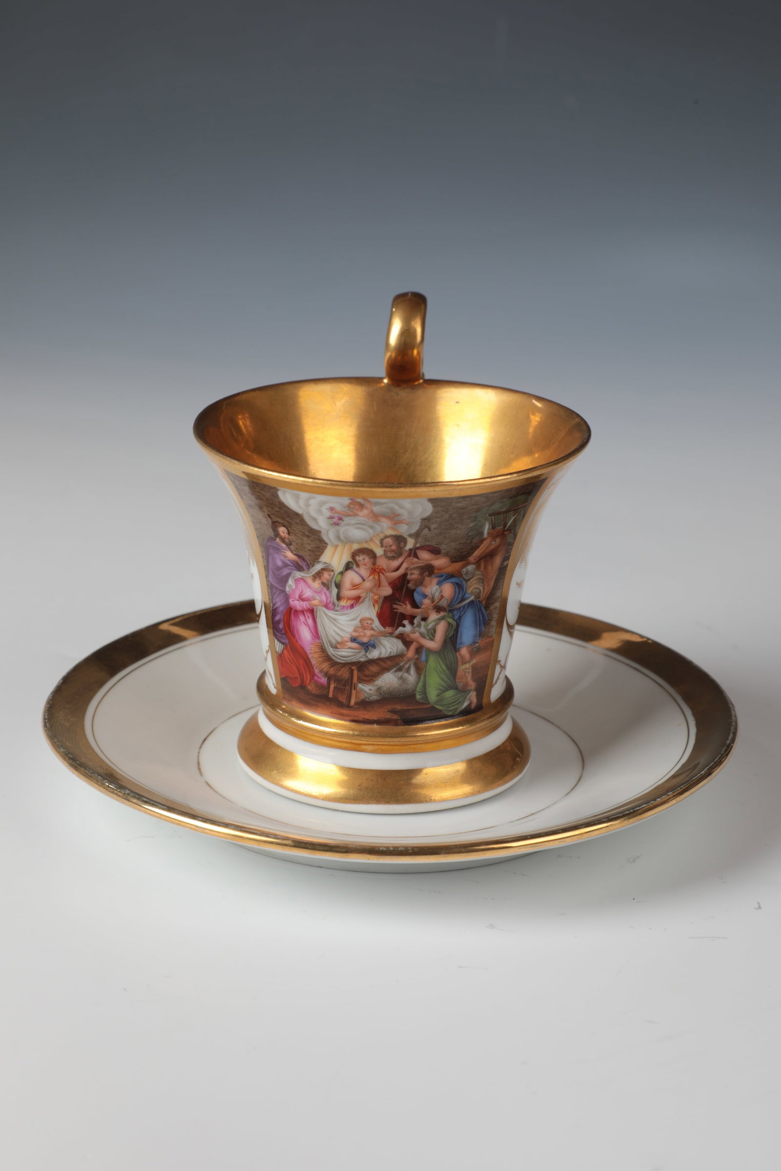 Cup and saucer ''Adoration of the Christ Child'': Cup and saucer ''Adoration of the Christ Child'' Probably Thuringia, mid/end of the 19th century. Conical swinging shape on flared round base with curved ear handle. Gilded inside. Finely painted