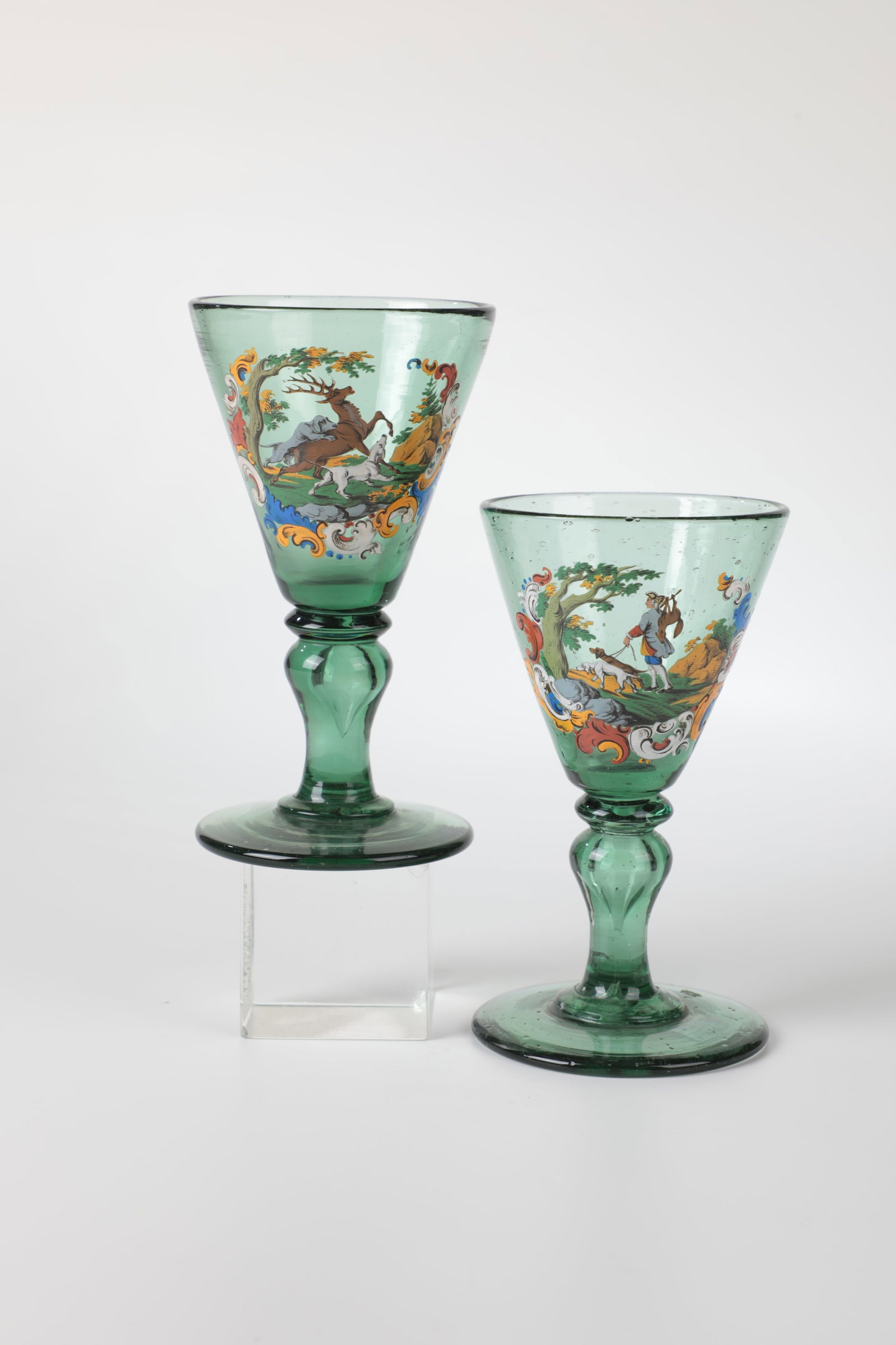 Couple of goblets with hunting scenes: Pair of goblets with hunting scenes Anton Ambros Egermann, Haida, c. 1880 Green glass. Hunting scenes executed on the wall in bright enamel colours, framed by seed ornaments. H. 15 cm Paar Pokale mit