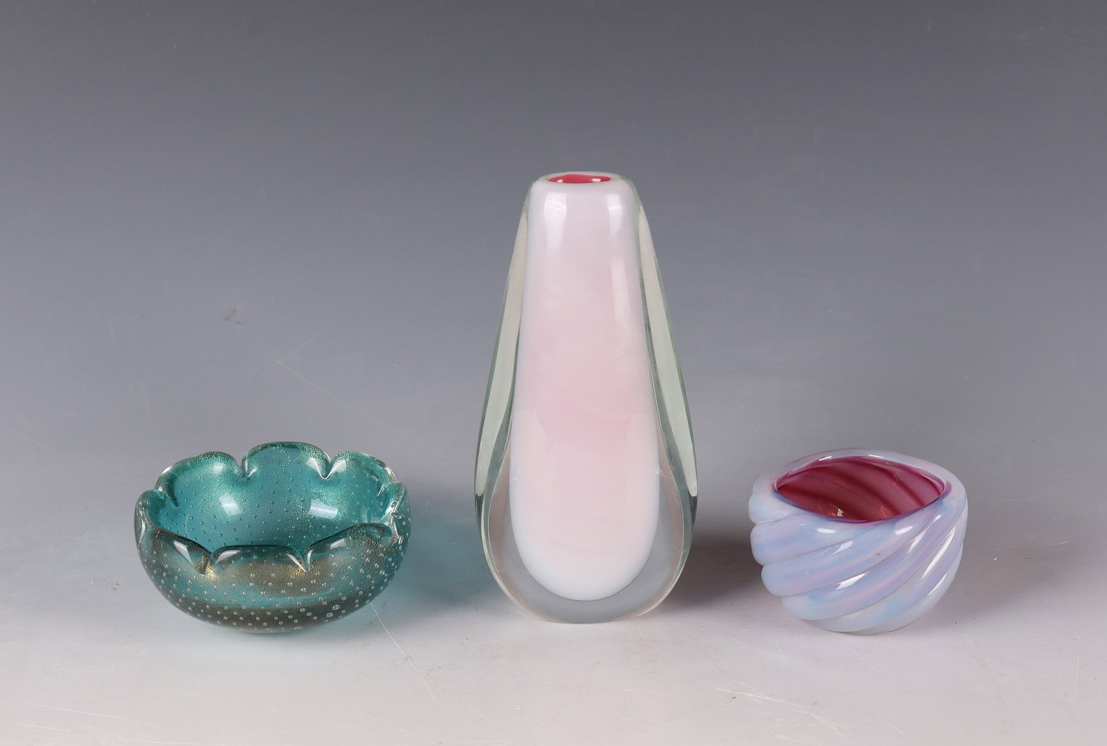 Mixed lot: two bowls, a vase: Mixed lot: Two bowls, a Murano vase, after 1955 Colourless glass, underlaid with aquamarine green. Between the layers, air bubbles worked in several rows as well as burst gold foil melting. Underside