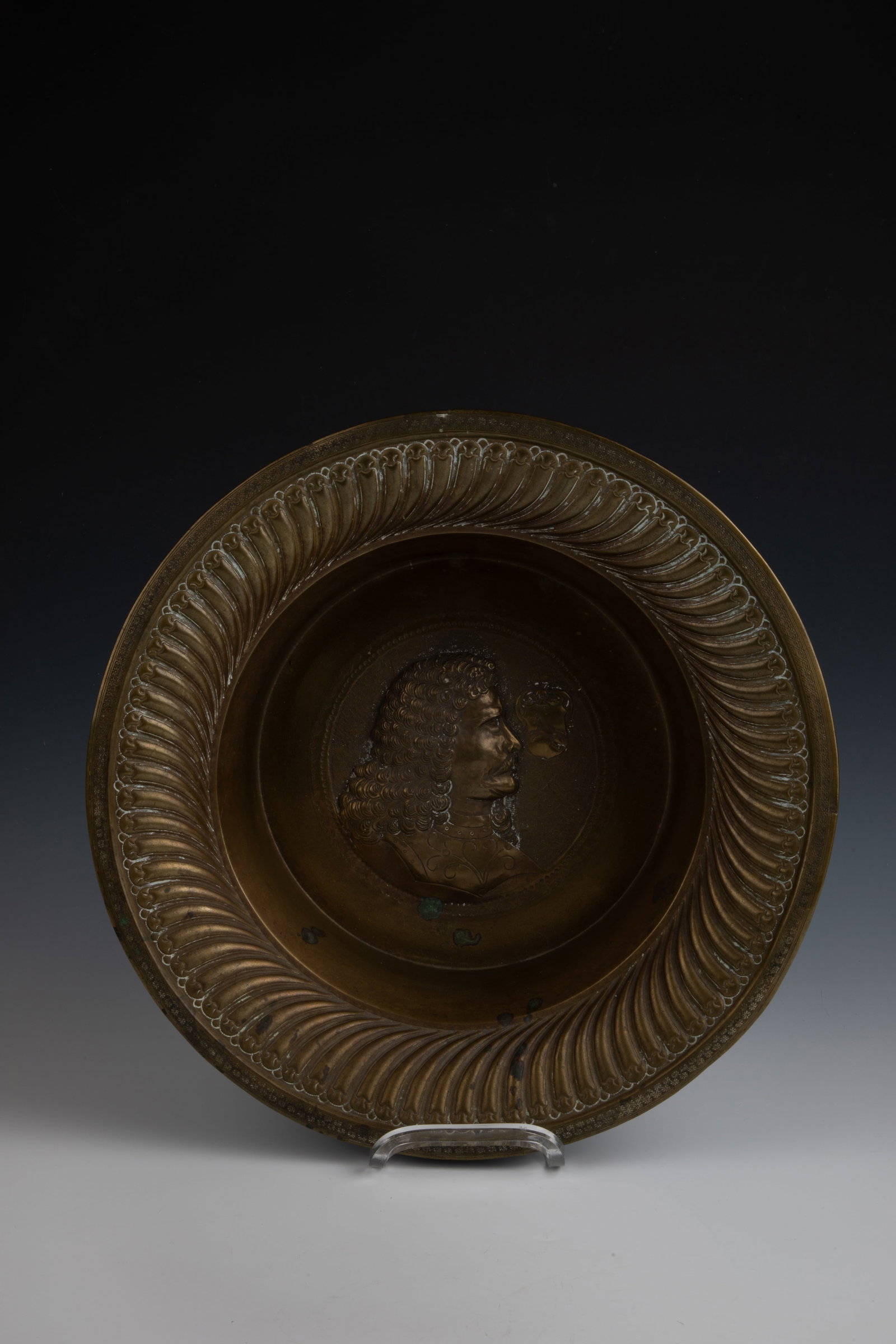 Brass bowl with men's portrait: Brass bowl with portrait of a gentleman, E. 18. A. 19th century, brass sheet embossed. Flag with radial ribbed pattern and chased floral pattern on the edge. In the mirror, a portrait of a noble gentl