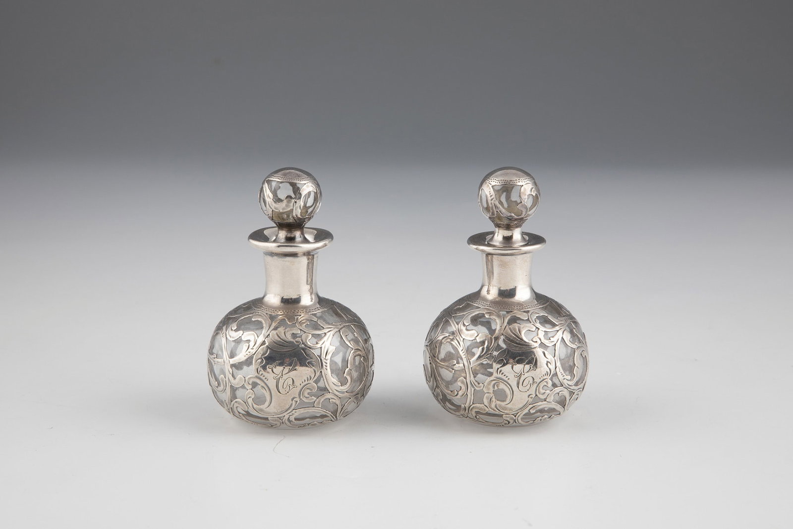 Two bottles with galvanized fine silver decoration: Two bottles with galvanized fine silver decoration Colorless glass with floral glavanized fine silver decoration and an initial ''C''. Silver indistinctly stamped with ''A. Frankfield & Co.