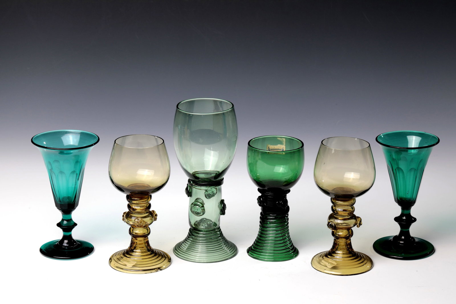 Mixed Lot of Four Romans and Two Pointed Chalices: Mixed lot of four Romans and two pointed chalices, 19th century. Disc or ribbed trumpet feet, discs. or spherical nodes with applied berry nubs. Bulbous or trumpet-shaped cuppas. Partly bumped. H. 13 