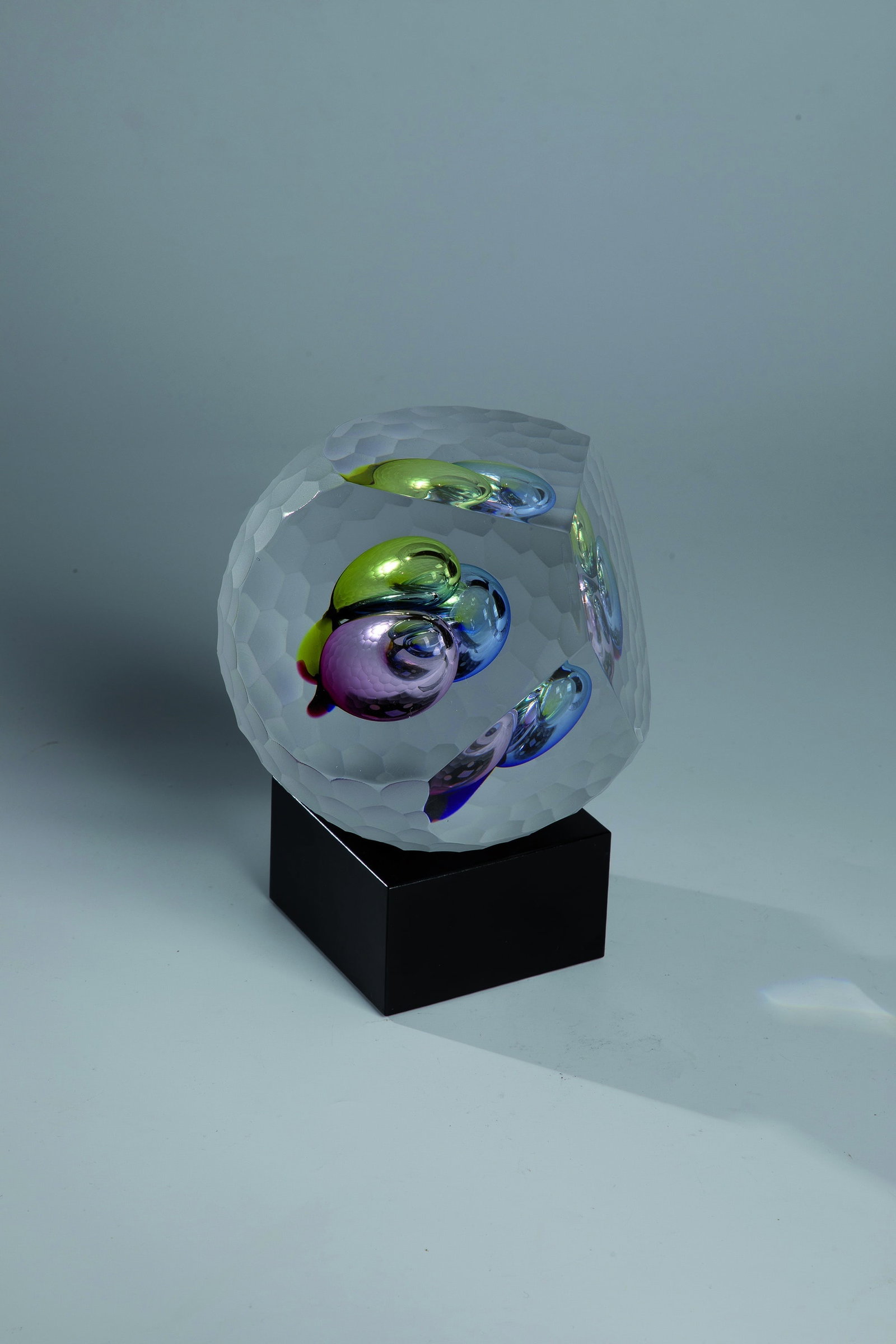Object: Object Robert Phillips, Ahus / Sweden, ca. 2018 ''Color Bubbles'' - Colourless, partly cut-decorated glass with blue, yellow and pink, bubble-shaped inclusions. In the ground inscribed: Phillips