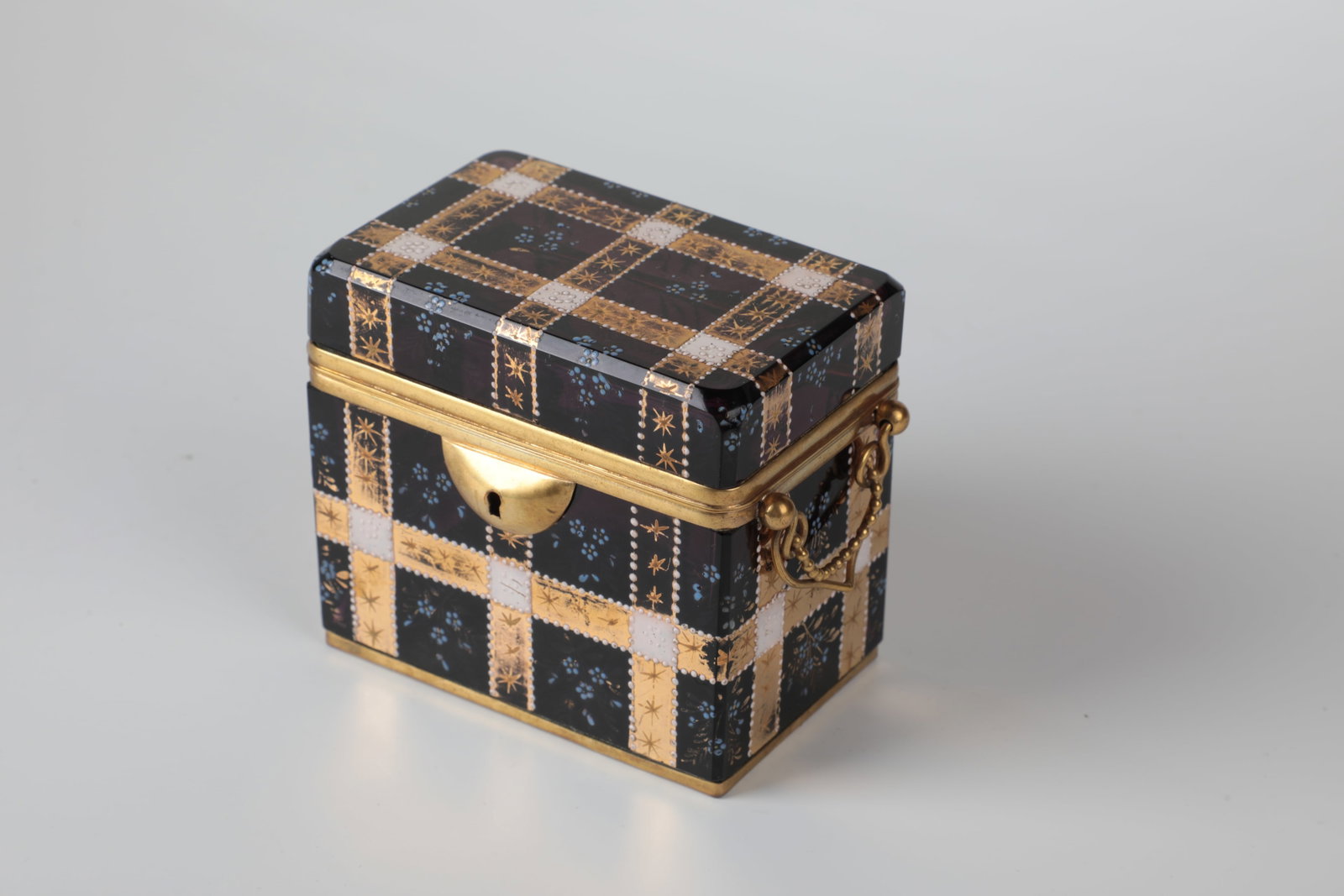 Lidded jar: Lidded box, Bohemia or France, M. 19th century, amethyst-coloured glass. Rectangular with beveled edges. Area-filling square décor in gold and enamel painting. Brass mount. Key provided. 10 x