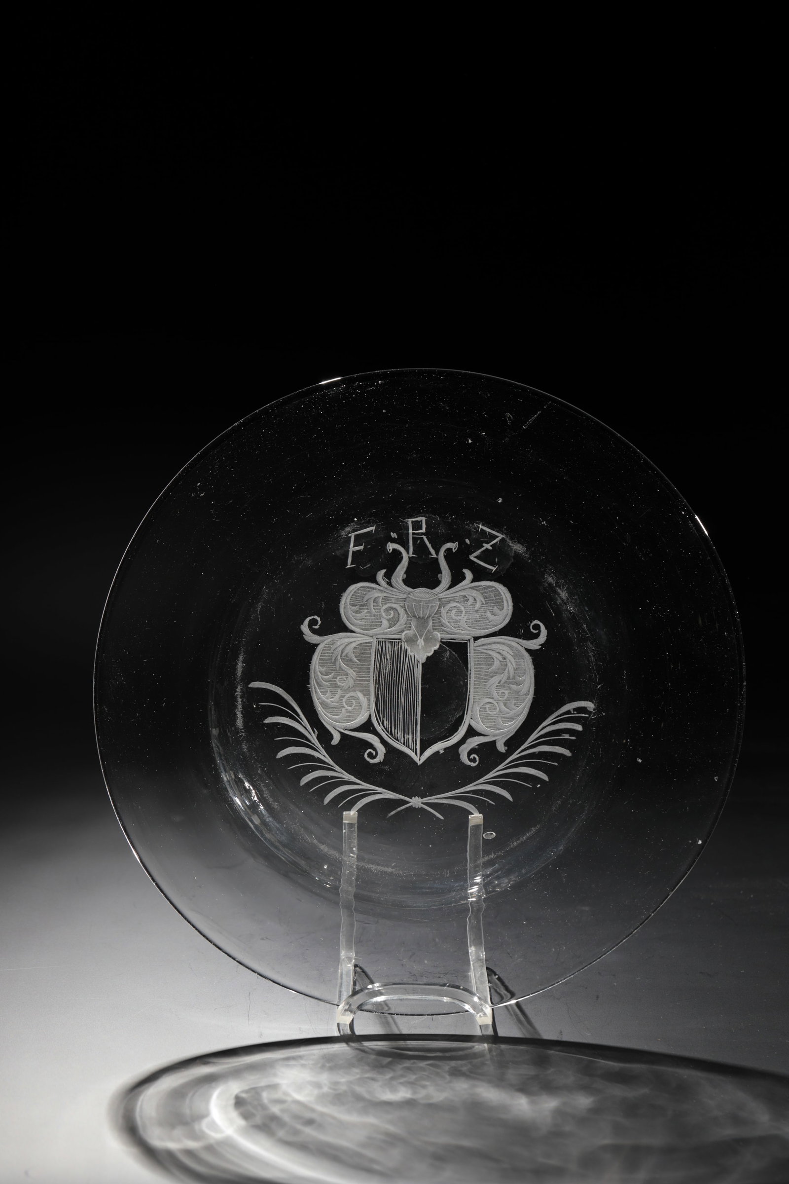 Plate: Plate Saxony or Bohemia, 18th century Colourless glass with ground tear-off. Coat of arms cut in the mirror over crossed palm branches, above initials ''FRZ''. D. 24.5 cm Teller Sachsen oder