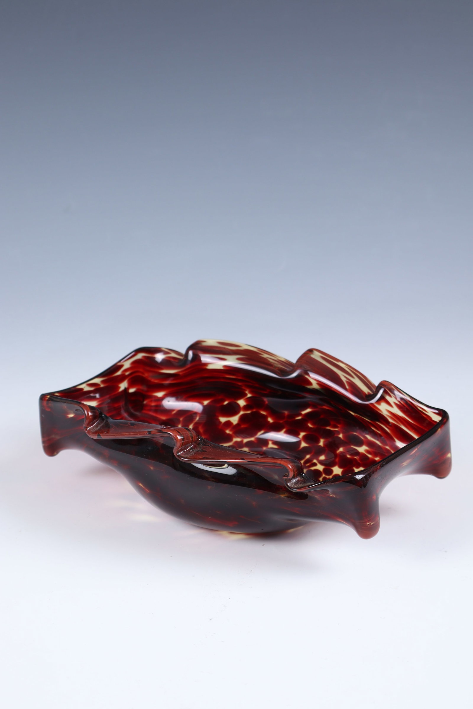 Shell: Shell Bohemia, around 1930 Colourless glass, thinly yellowish underlaid and reddish-brown spots melted in between the layers. Muzzles warped or jagged. Underside with adhesive label ''(?) FERRATA